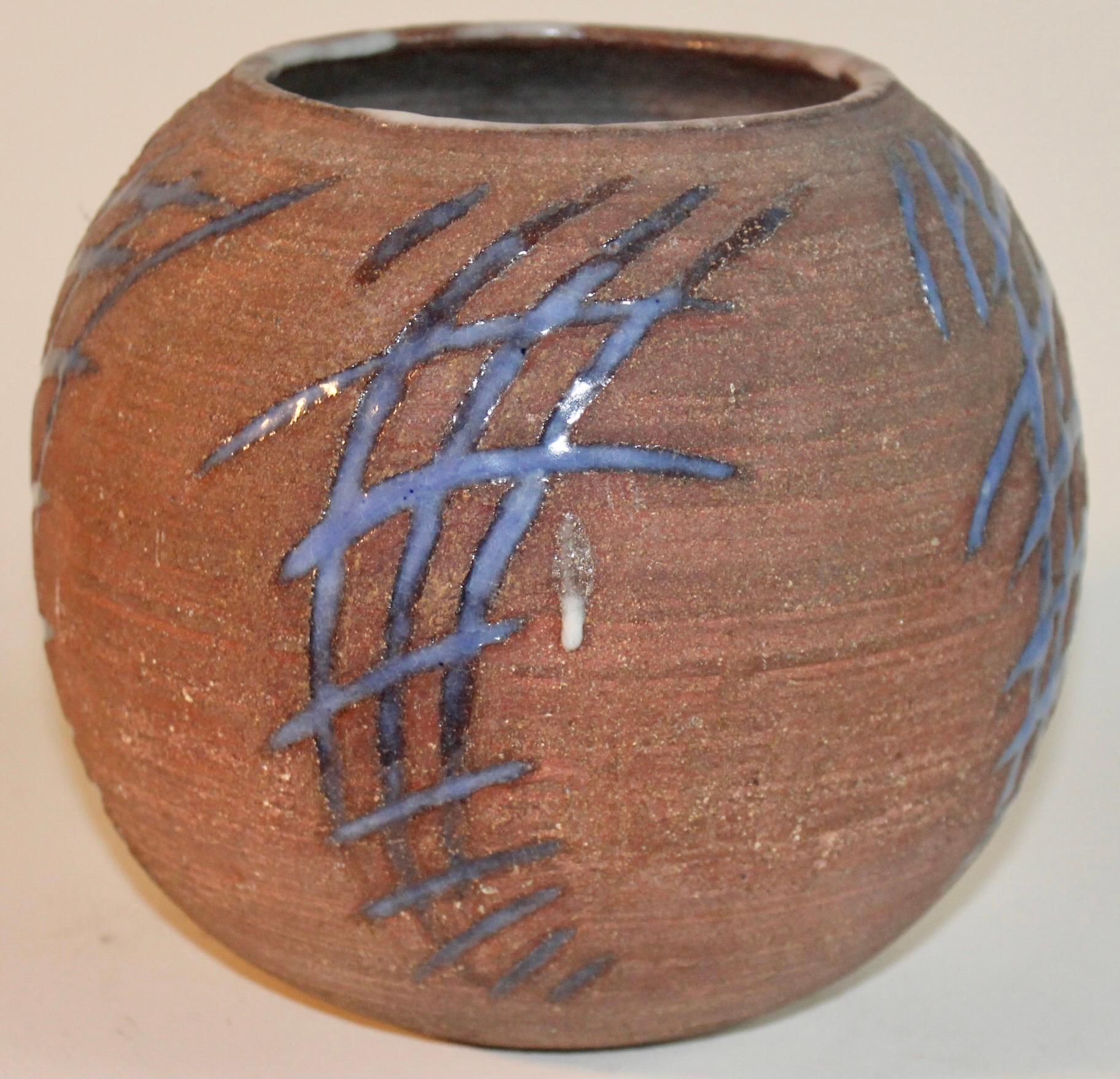 A stoneware round vase, bisque surface, interior glazed and with a strong blue abstract intaglio glazed decoration, typical of Grotell's Cranbrook Academy of Art style, where she worked and headed the ceramics department from 1938-1966.
Signed with