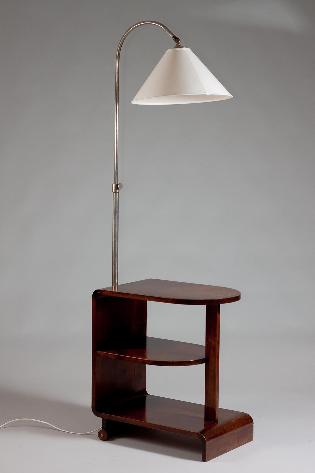 Te presentamos la mesa auxiliar Maija Heikinheimo Apu, una impresionante pieza vintage que destila encanto de los años 30. Esta elegante mesa se ha modificado para incluir una lámpara incorporada y posavasos, lo que la hace a la vez funcional y