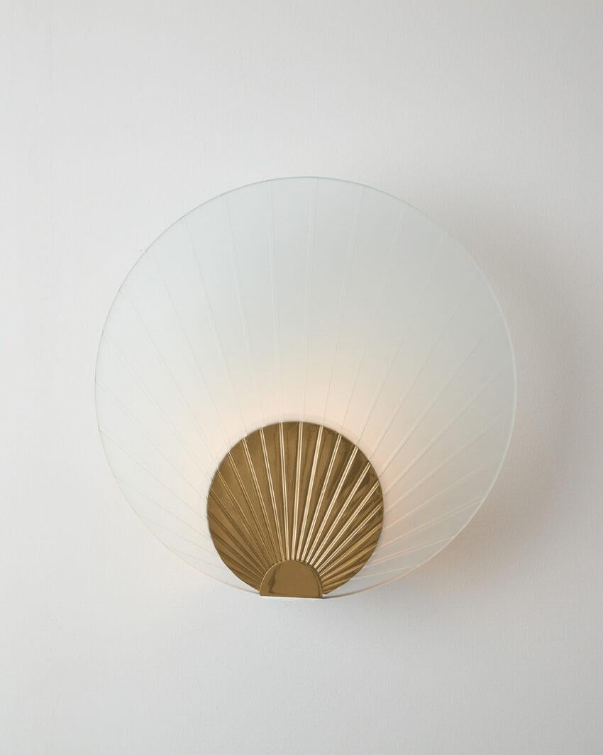 Maiko Clear Glass And Polished Brass Wall Mounted Lamp by Carla Baz
Dimensions: Ø 35 x D 14 cm.
Materials: Polished brass and clear glass.
Weight: 3,5 kg.

Available in different finishes: verdigris metal, brushed brass, brushed copper, brushed