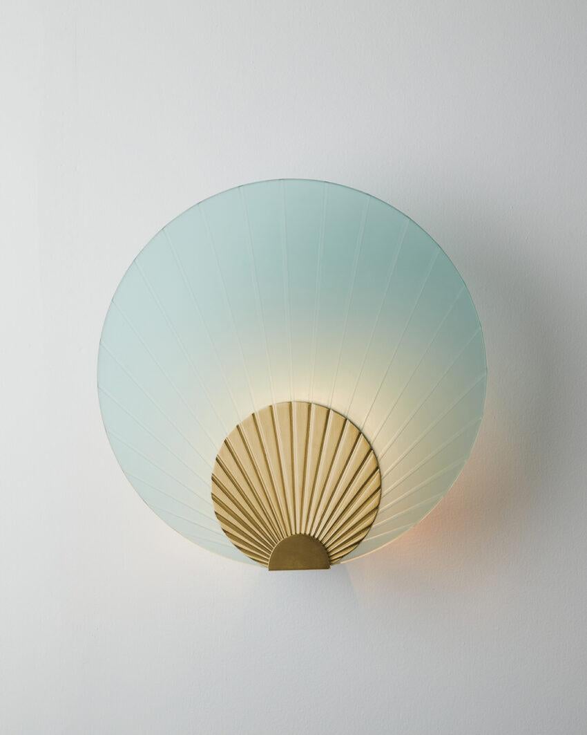 Maiko Mint Glass And Polished Brass Wall Mounted Lamp by Carla Baz
Dimensions: Ø 35 x D 14 cm.
Materials: Polished brass and mint glass.
Weight: 3,5 kg.

Available in different finishes: verdigris metal, brushed brass, brushed copper, brushed