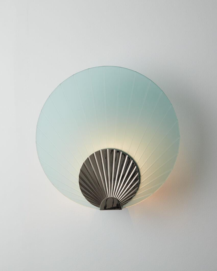 Maiko Mint Glass And Polished Stainless Steel Wall Mounted Lamp by Carla Baz
Dimensions: Ø 35 x D 14 cm.
Materials: Polished stainless steel and mint glass.
Weight: 3,5 kg.

Available in different finishes: verdigris metal, brushed brass, brushed