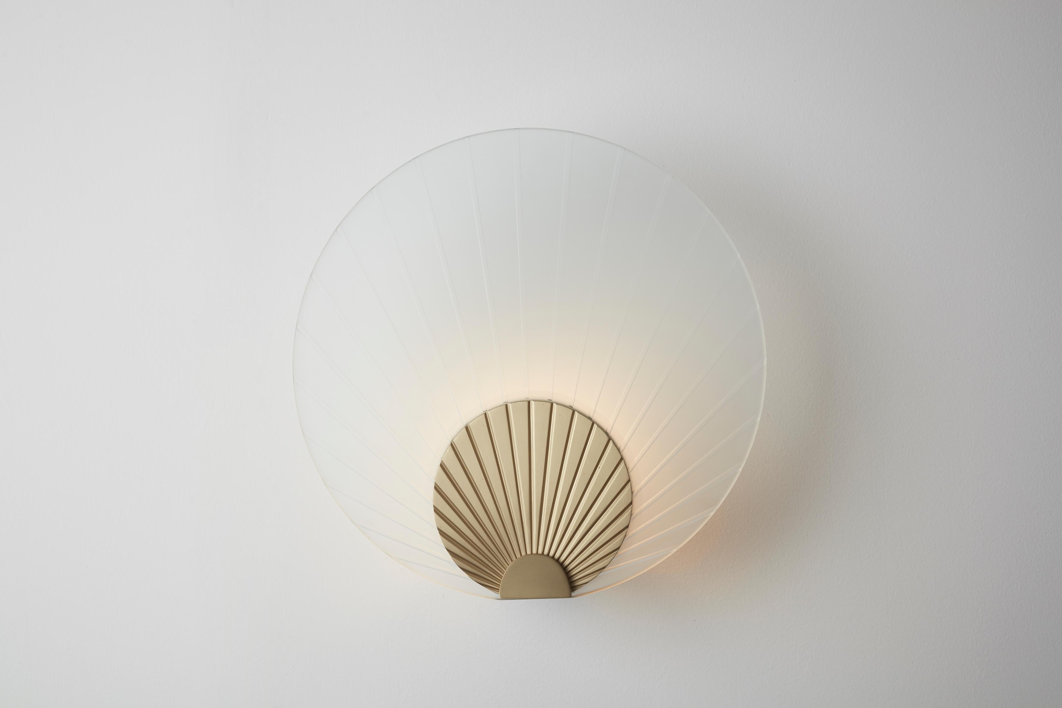 Maiko wall mounted brass and clear, Carla Baz
Dimensions: ø 35 x D 14 cm
Weight: 3.5 kg
Material: Brass

Maiko lighting pieces are inspired by the beautiful Japanese folding fans held by geishas and maikos during their notorious dances. These