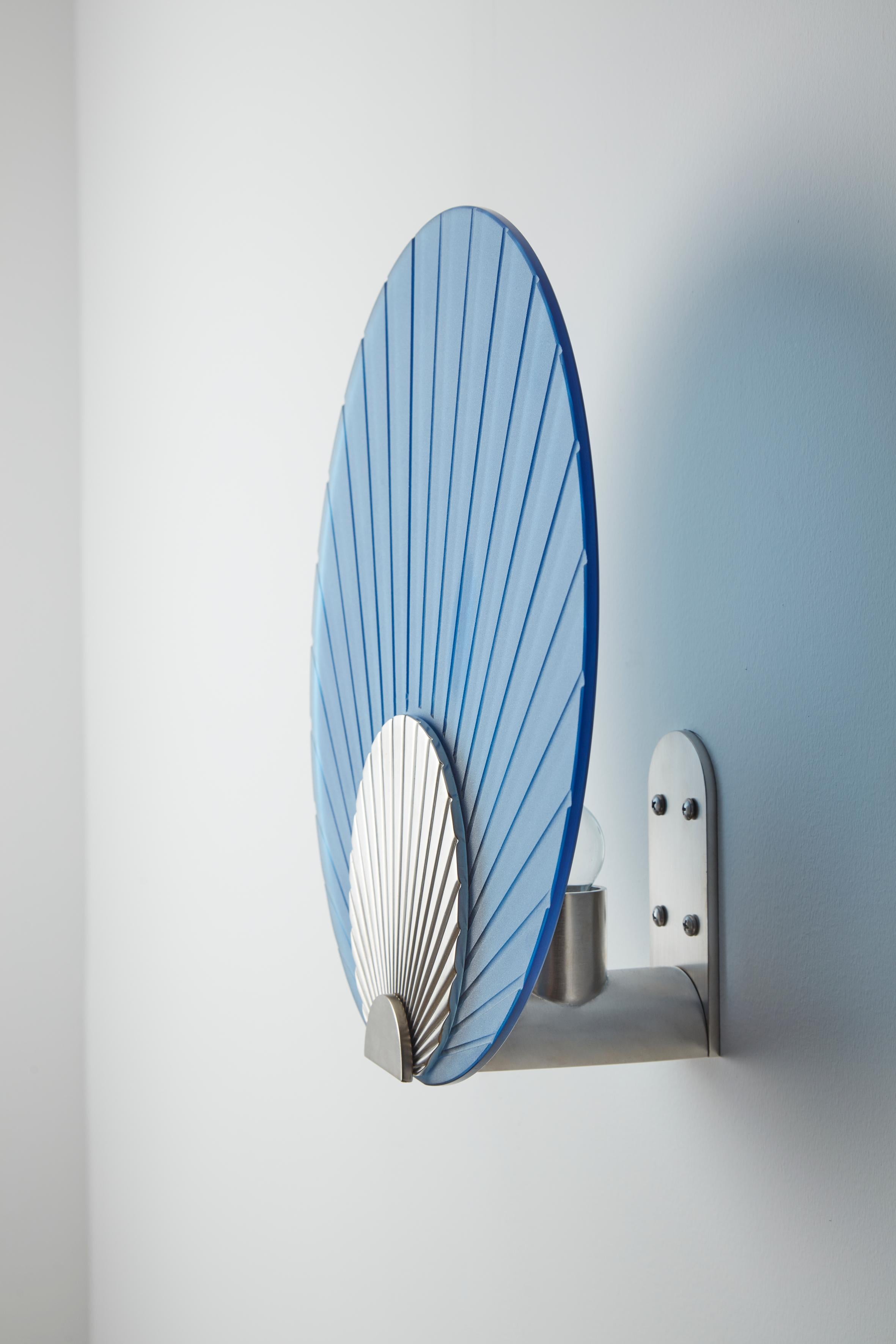 Maiko wall mounted nickel and blue, Carla Baz
Dimensions: ø 35 x D 14 cm
Weight: 3.5 kg
Material: Nickel

Maiko lighting pieces are inspired by the beautiful Japanese folding fans held by geishas and maikos during their notorious dances. These