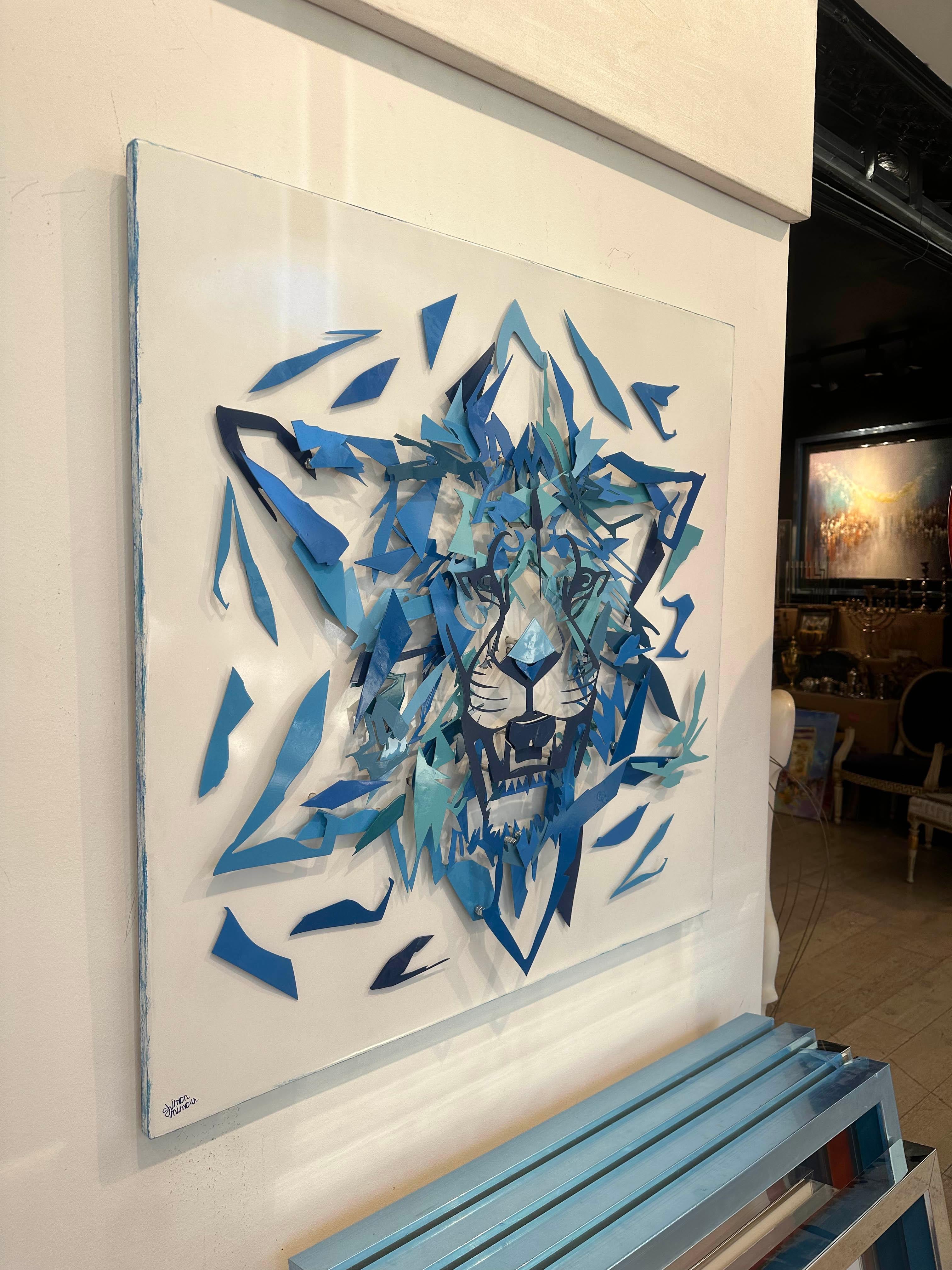 Questa sorprendente opera d'arte tridimensionale presenta un muso di leone intricato costruito con strati di metallo dipinti a mano in varie tonalità di blu. La composizione frammentata ma coesa forma non solo il leone, un simbolo tradizionale di