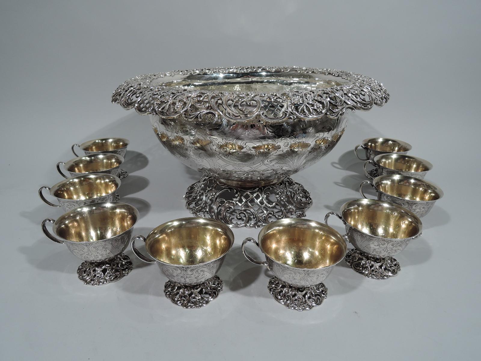 Main line magnificent sterling silver punch bowl and 10 cups. Made by JE Caldwell in Philadelphia, circa 1890.

Bowl: Curved sides, rolled rim, and dome foot. Rim and foot open with flowers, foliage, scrolls, and diaper. Exterior engraved with same.
