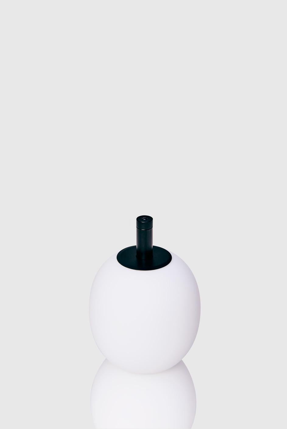 The Mainkai table lamp by Sebastian Herkner matches his playful shapes with sophisticated materials. The lamp’s integrated button on the top stem dims the glow of its hand blown glass globes. The LED light has a balanced color temperature of 2700K