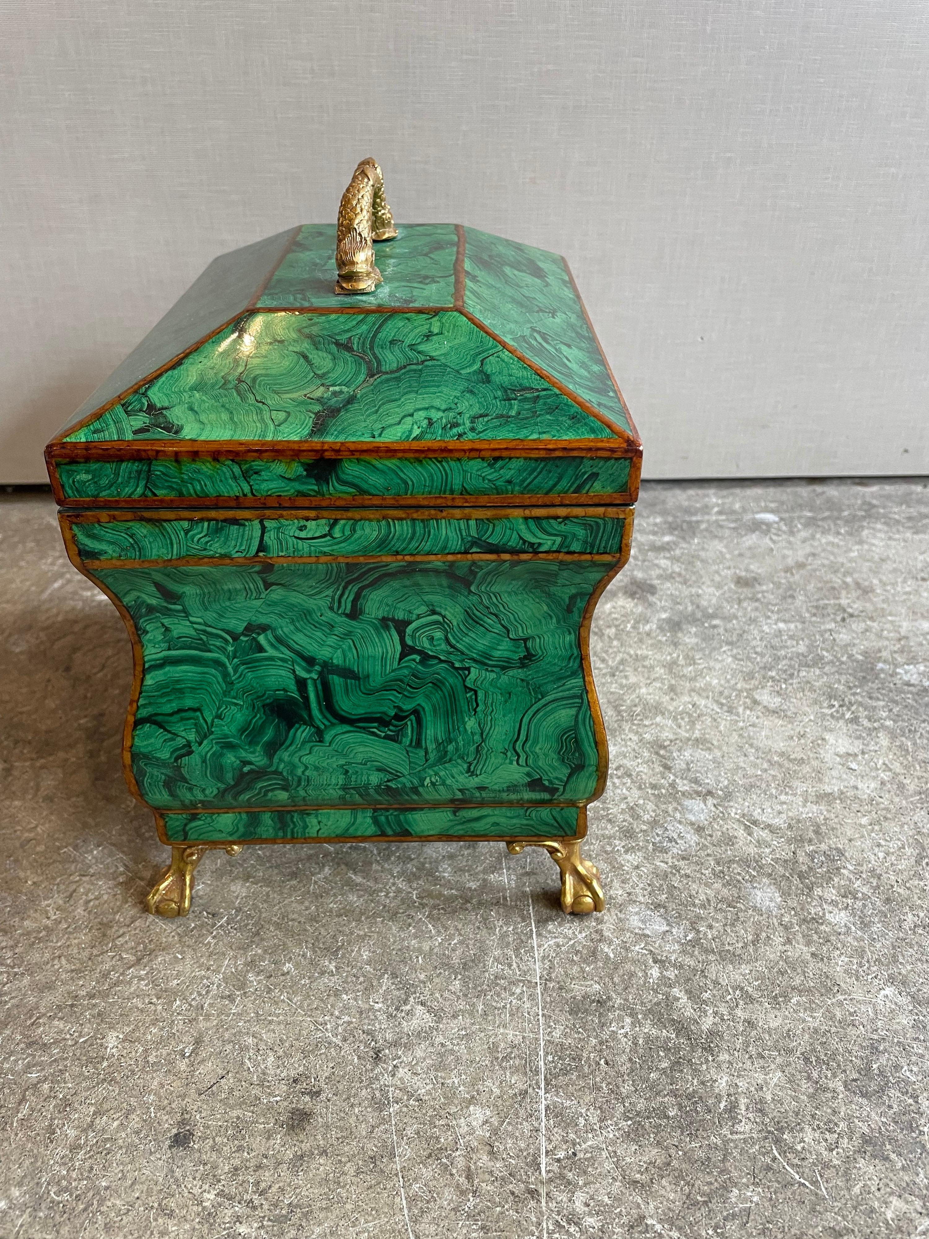 This is a wonderful large faux malachite box with gold handle and feet made by the company Maitland Smith.