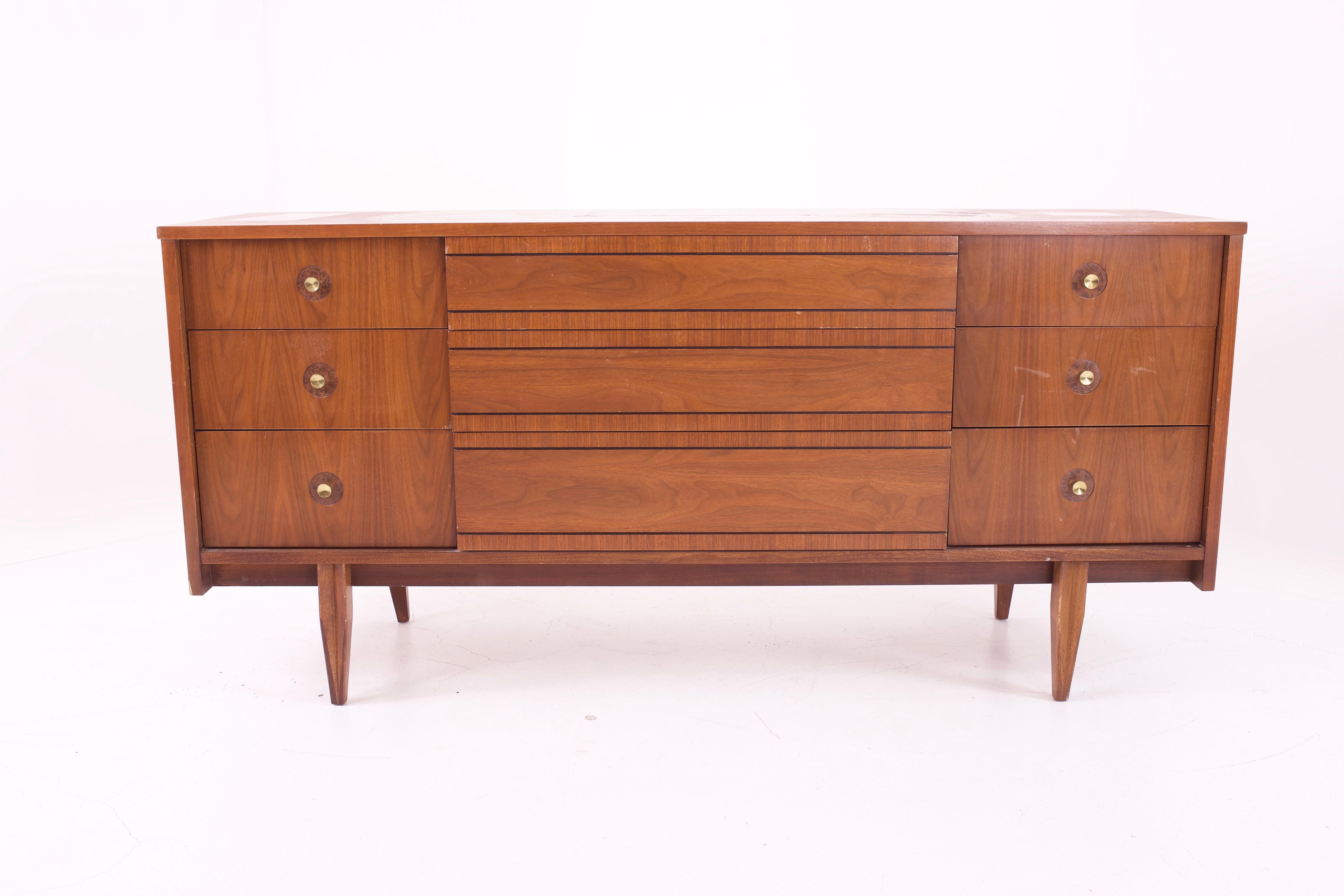 Mainline by Hooker Mid Century walnut and brass 9-drawer lowboy dresser 

Measures: 64 wide x 18 deep x 30.25 high 

Restored vintage condition. Piece is restored upon purchase so it’s free of watermarks, chips or deep scratches with color loss.