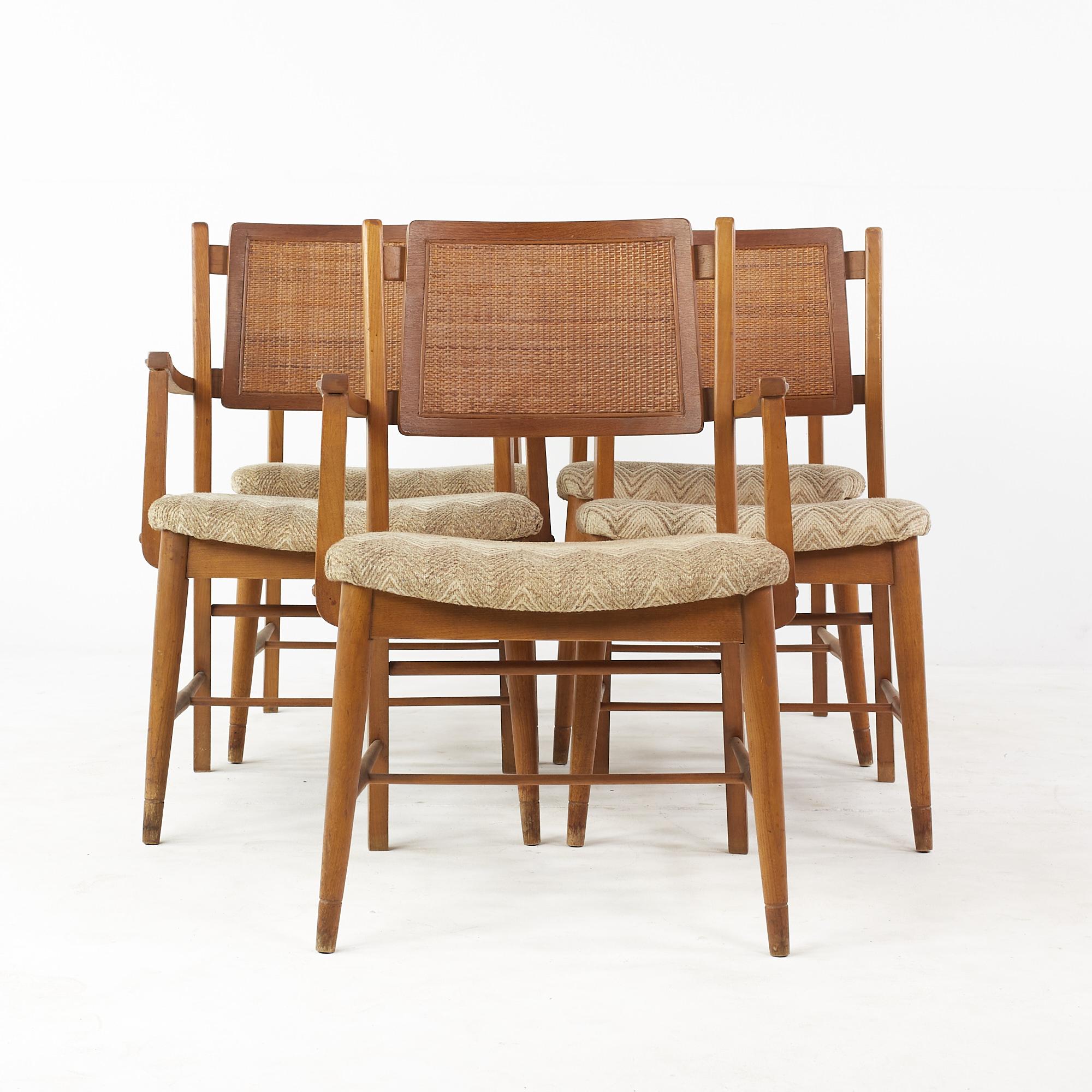 Mainline by Hooker Mid Century Walnut and Cane Dining Chairs – Set of 5

Each armless chair measures: 19.5 wide x 21 deep x 33 high, with a seat height of 17.5 inches
Each captains chair measures: 22.5 wide x 21 deep x 33 high, with a seat height of
