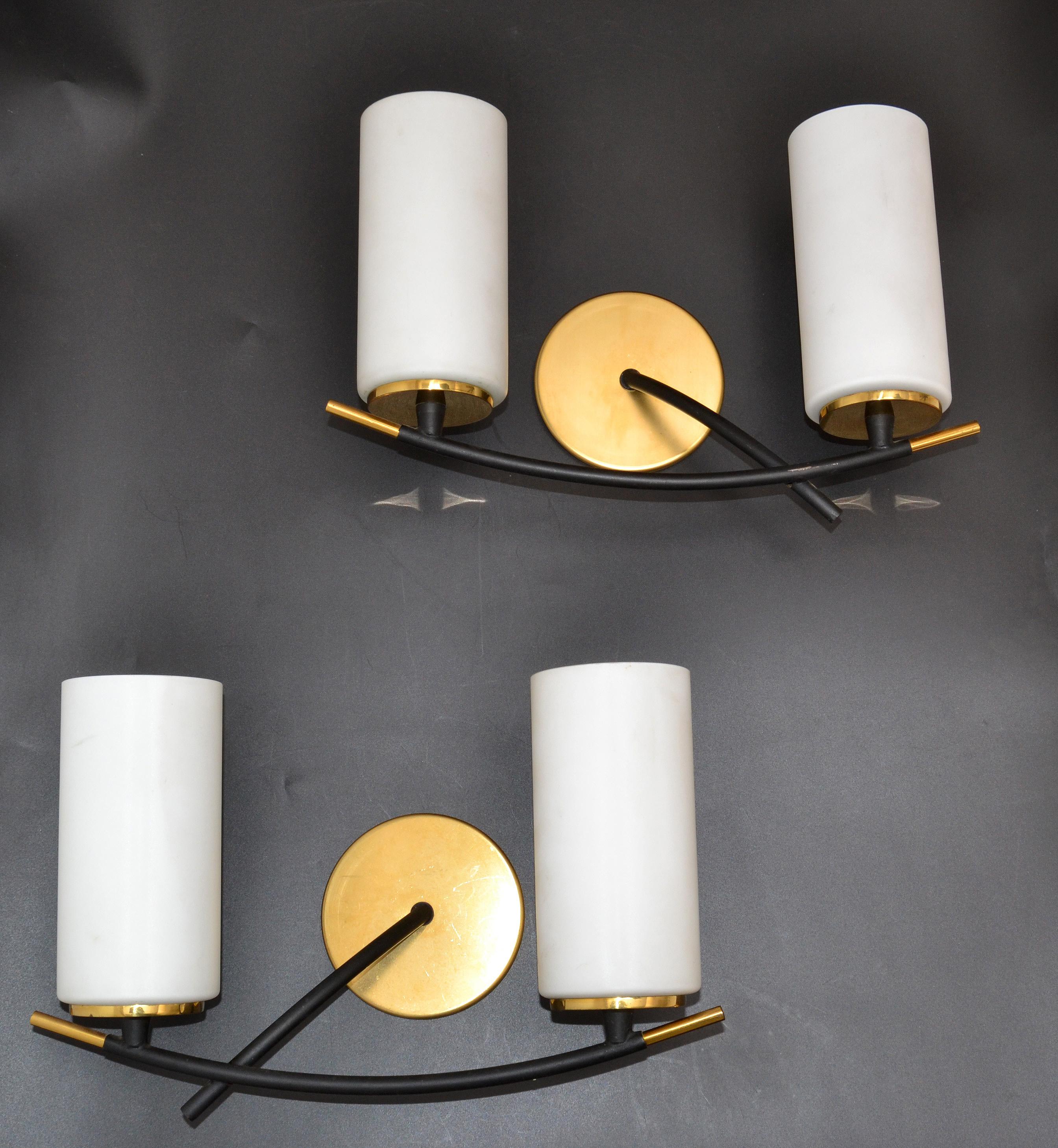 Paire d'appliques et d'appliques murales Maison Arlus à 2 lumières avec des abat-jour cylindriques originaux en opaline, en acier avec des détails en laiton.
Les deux sont de la même taille et sont l'image miroir l'un de l'autre, superbe design