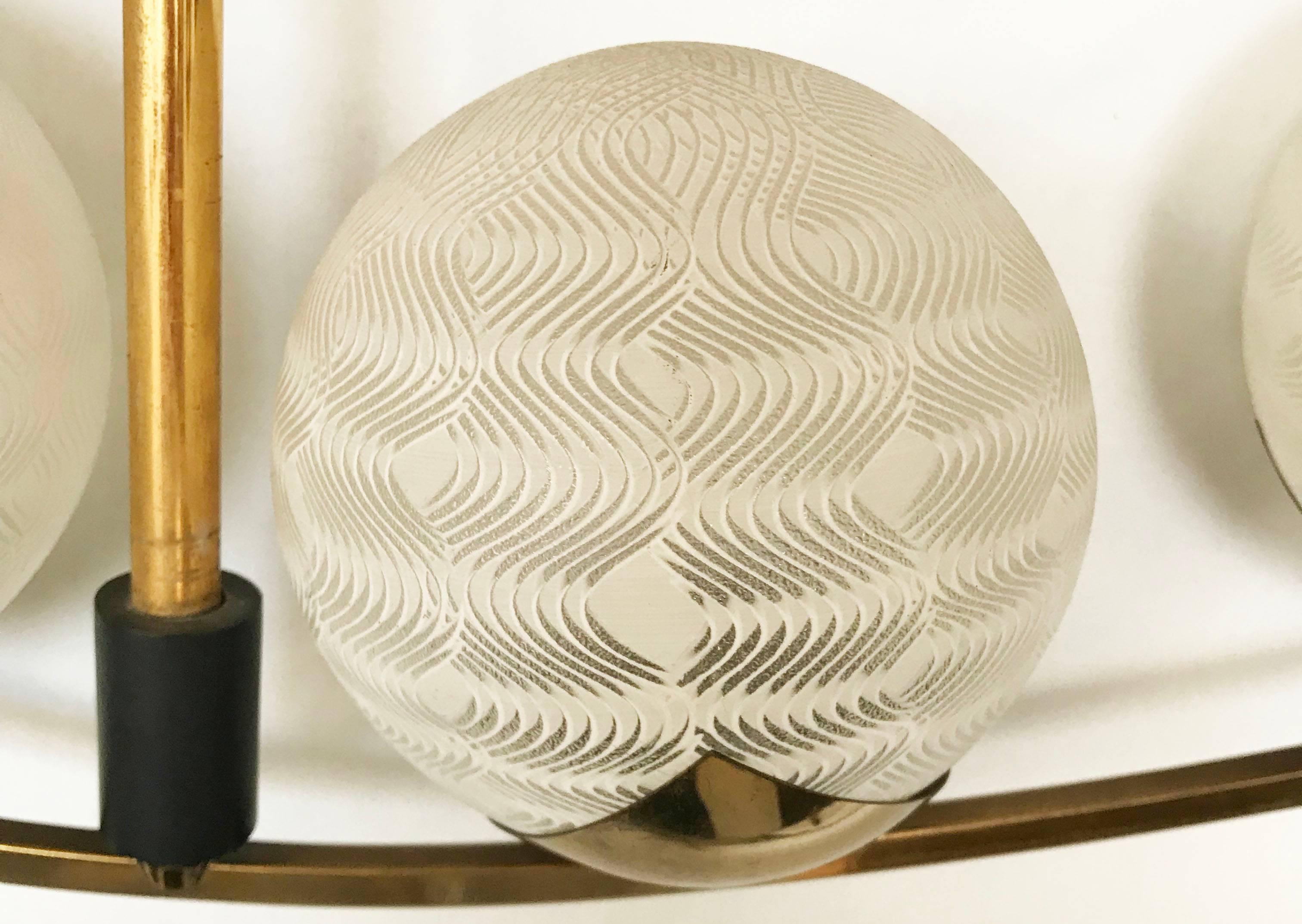 Splendido lampadario francese a quattro luci della Maison Arlus in ottone lucido, legno, metallo e paralumi in vetro opalino soffiato.
Design moderno di metà secolo realizzato in Francia nel 1960.
Ricablata e funzionante, può contenere 4 lampadine