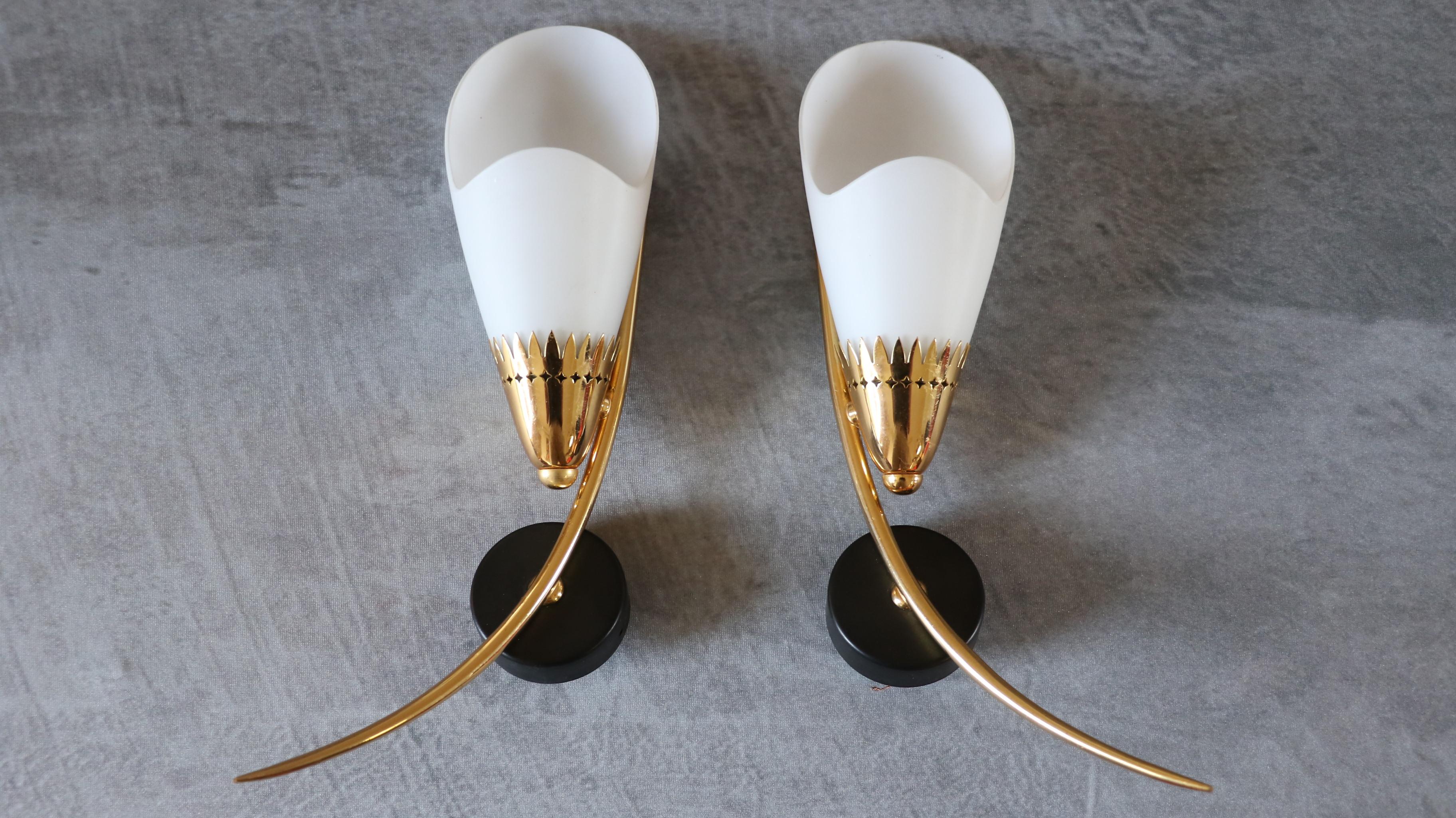 Pair of Mid-Century French Wall Sconces by Maison Arlus, 1950s

A striking pair of mid-century wall sconces by the renowned French lighting manufacturer Maison Arlus, dating from the 1950s. These elegant fixtures feature a refined combination of