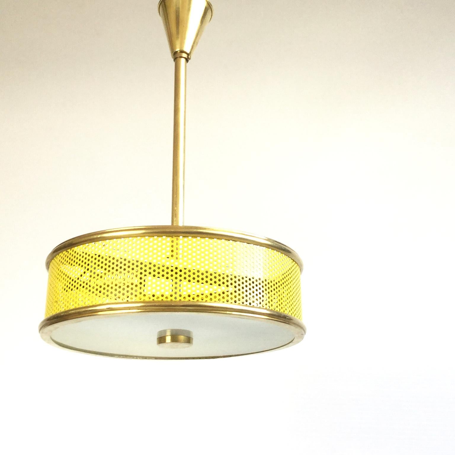 Hanging lamp from the 1950s with a yellow perforated metal lampshade and a frosted glass
Completely rewired with 2 lamp sockets.