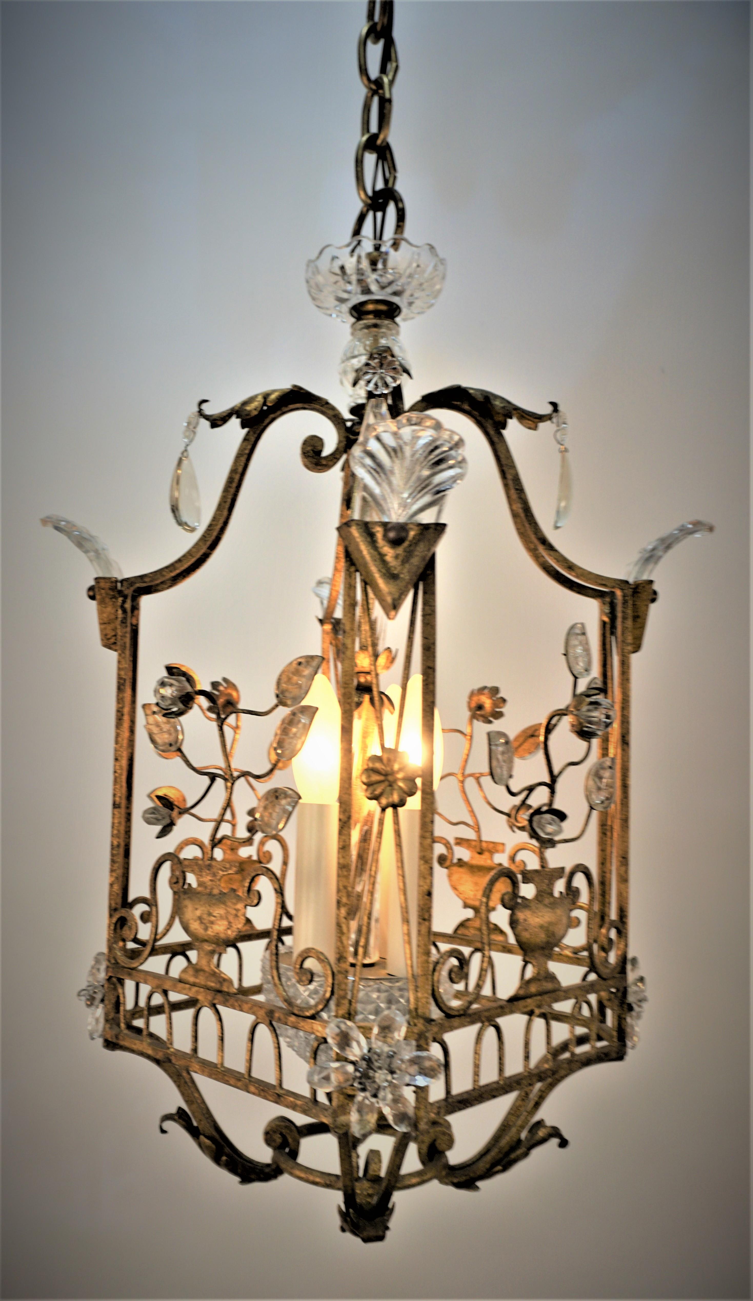 Gilt iron and crystal lantern / chandelier by the prestigious Maison Baguès.
Square four light handmade gilt bronze with crystal leaves and flora, beautiful piece of art. 
Measurement: 12