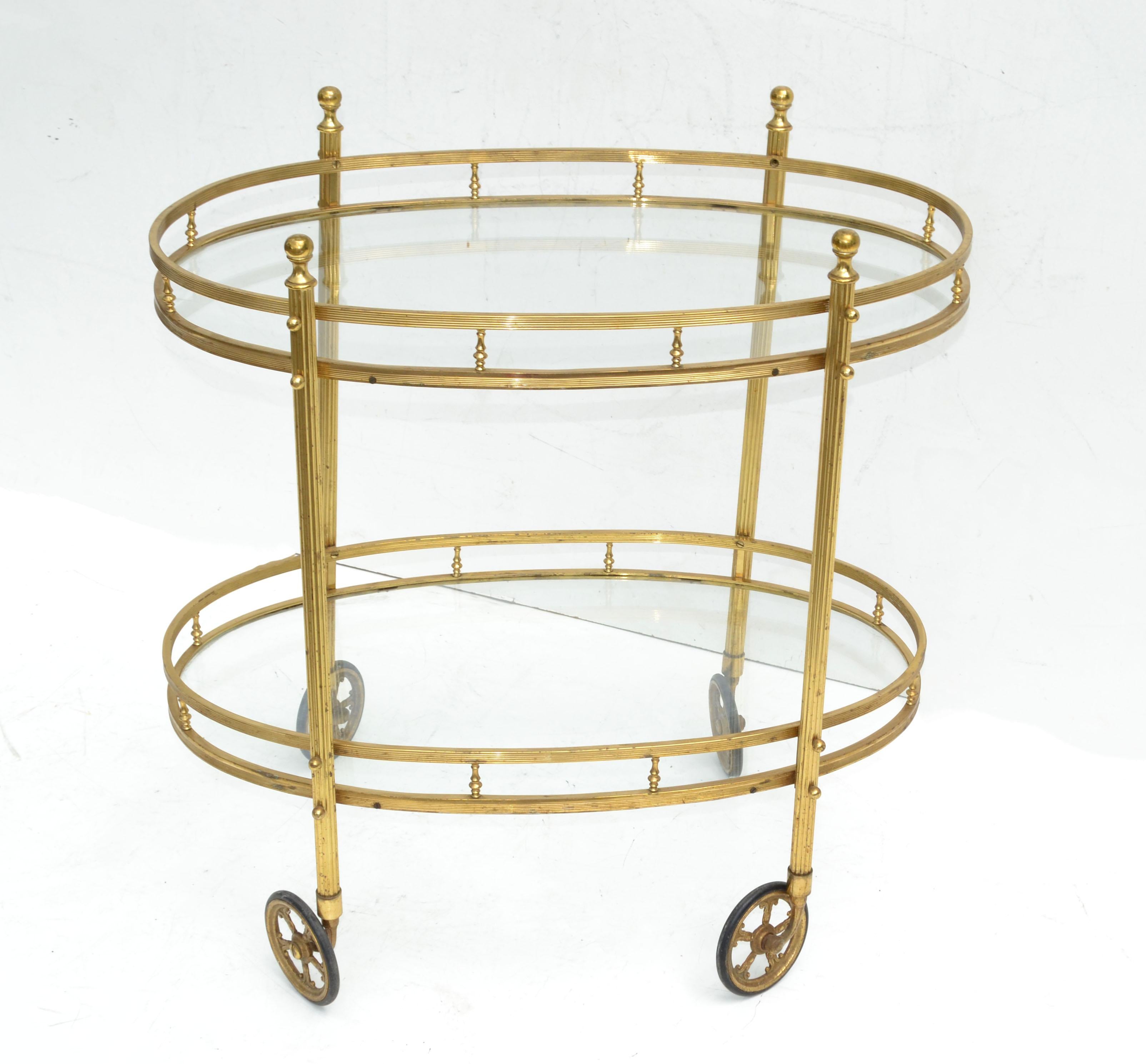 Superb bar cart made by Maison Bagués in France circa 1950.
Features 2 tier glass shelves with brass detail in oval shape.
Space in between measures 13 inches.