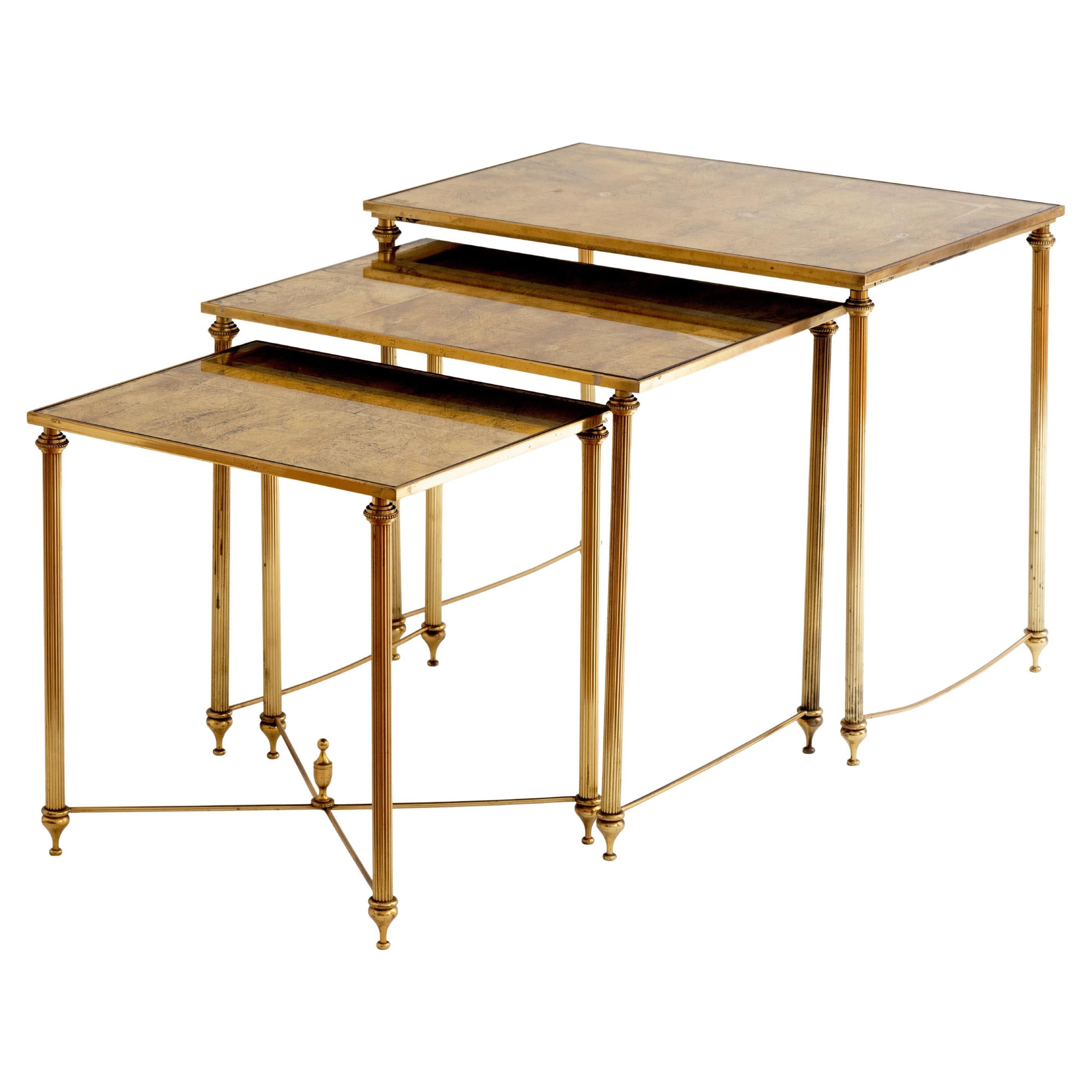 Cette rare et étonnante série de trois tables gigognes en métal doré de la prestigieuse maison de design française Maison Baguès, incarne une sophistication intemporelle et un savoir-faire exquis qui exsude l'opulence. L'une des tables possède une