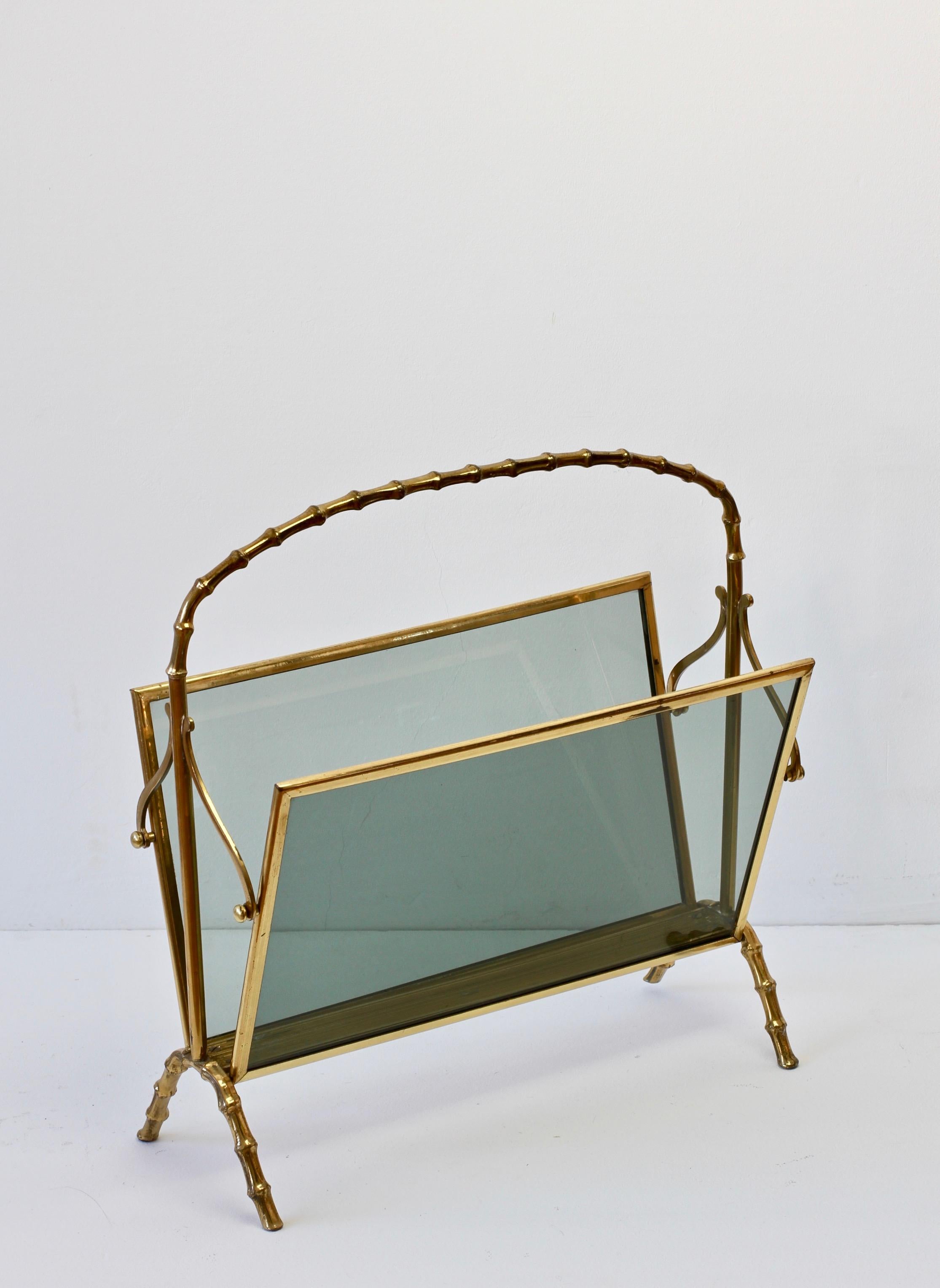Maison Baguès attributed cast brass and smoked dark toned glass magazine / newspaper / book rack, holder or stand, perfect for the Hollywood Regency style, in faux bamboo. Made in France circa 1950s, perfect for any midcentury collector or