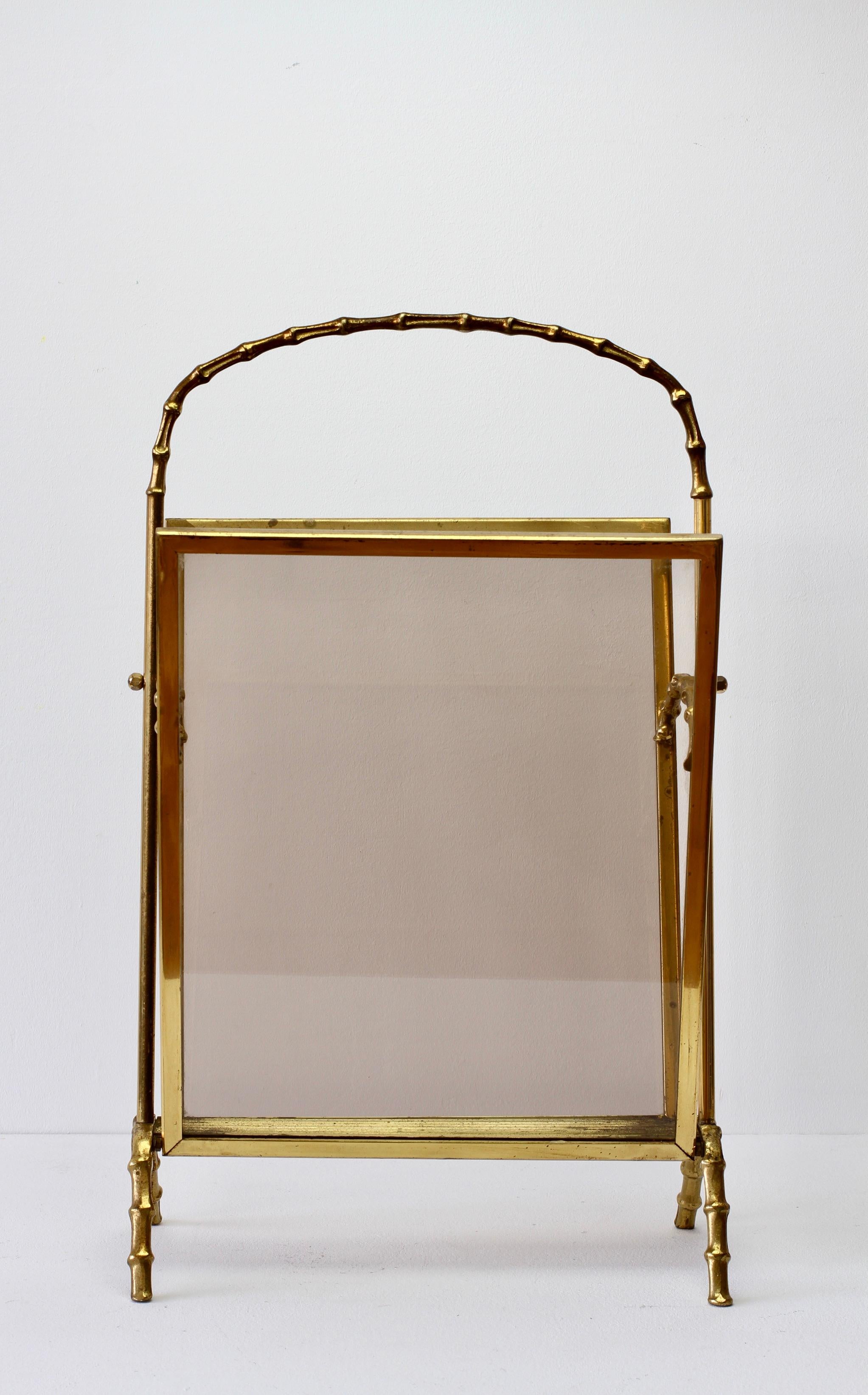 Maison Baguès attributed cast brass and smoked dark toned glass magazine / newspaper / book rack, holder or stand - perfect for the Hollywood Regency style - in faux bamboo. Made in France circa 1950s, perfect for any midcentury collector or