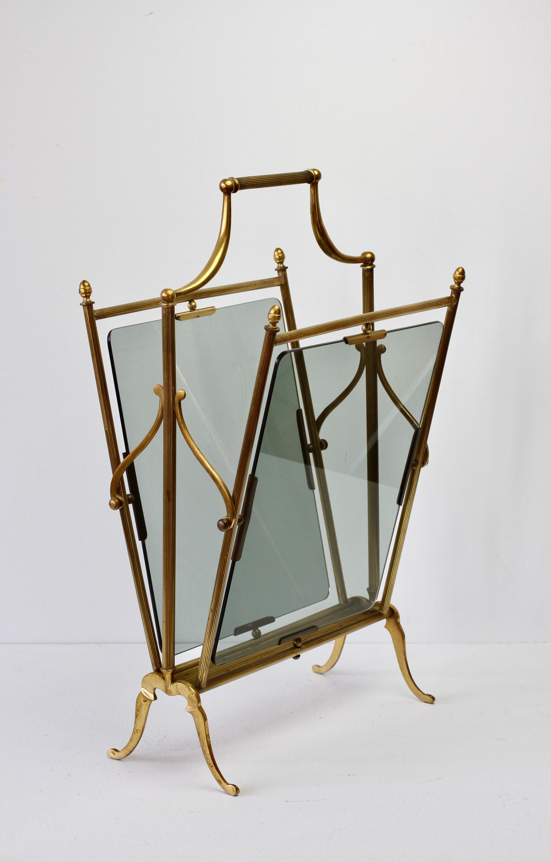 Midcentury vintage brass and dark 'smoked' toned glass magazine / newspaper / book rack, holder or stand, attributed to Maison Baguès, made in France, circa 1940s-1950s. Perfect for the Hollywood Regency style - perfect for any midcentury collector