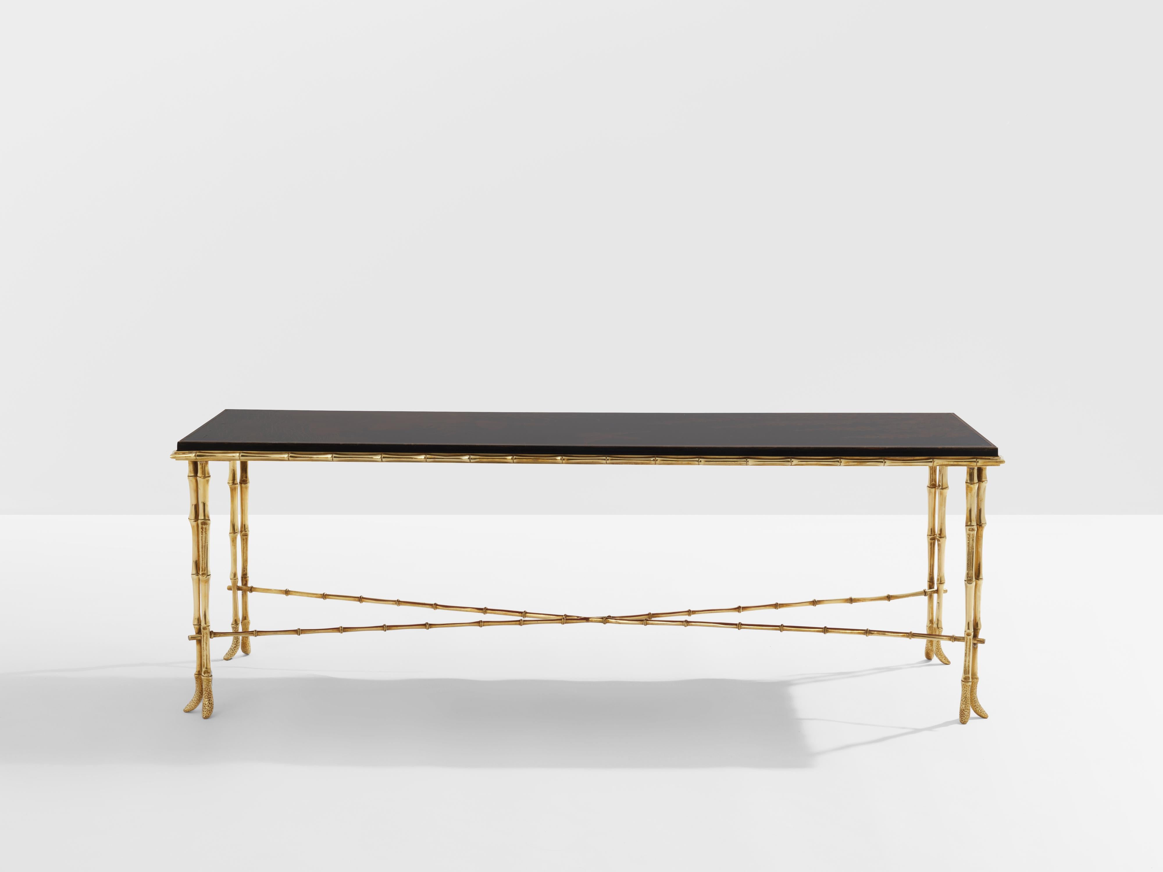 This coffee table by French house Maison Baguès was created in the early 1950s with solid bamboo shaped brass structure and a beautiful black Chinese lacquered top picturing a natural scene with a river, flowers, leaves and a bird flying. The