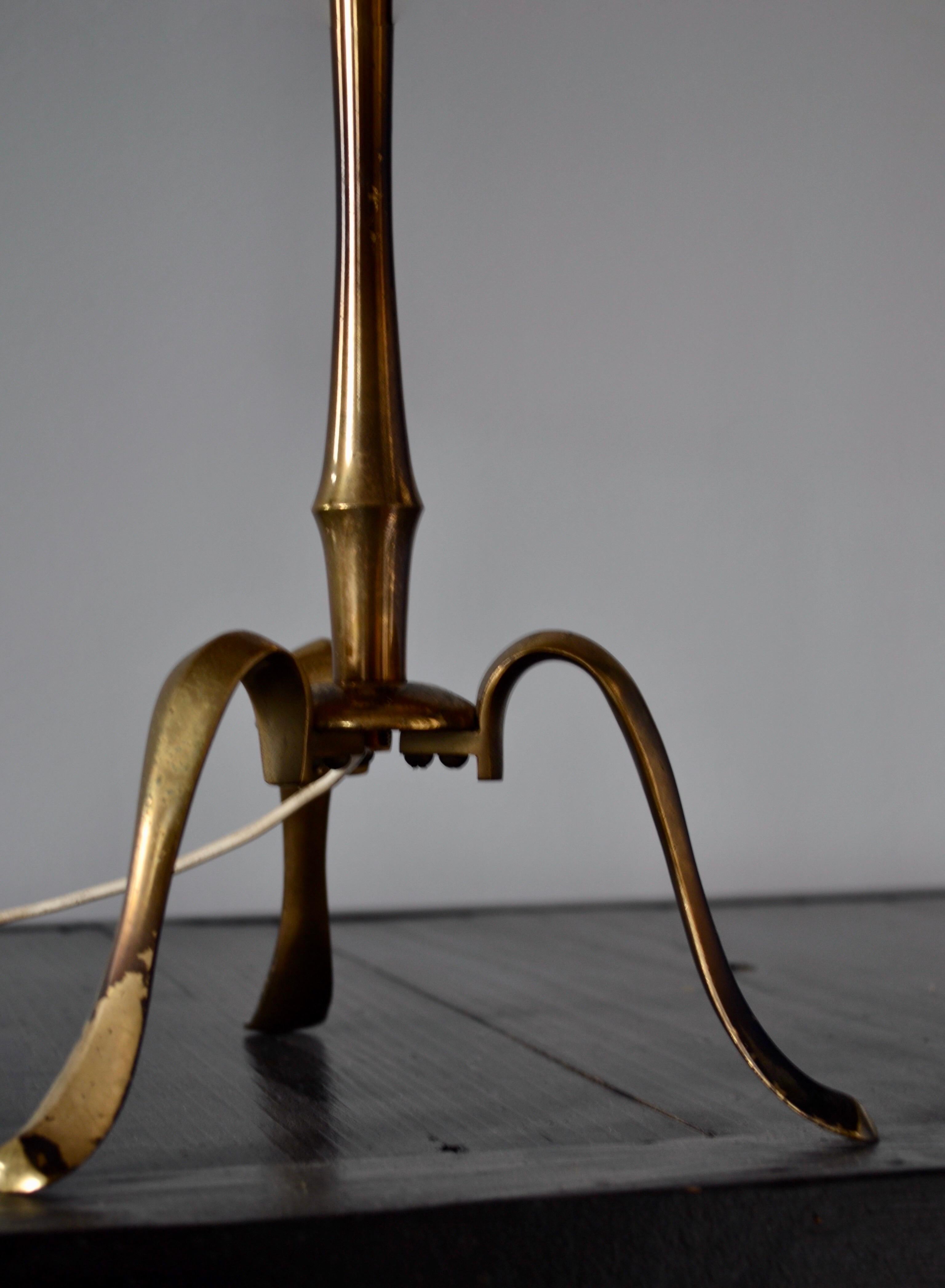 Esta lámpara de sobremesa Maison Bagues, elaborada en bronce dorado con detalles de bambú sintético, desprende una notable sofisticación. La sutil pátina de los pies de la lámpara añade un auténtico toque de carácter. La original pantalla negra y