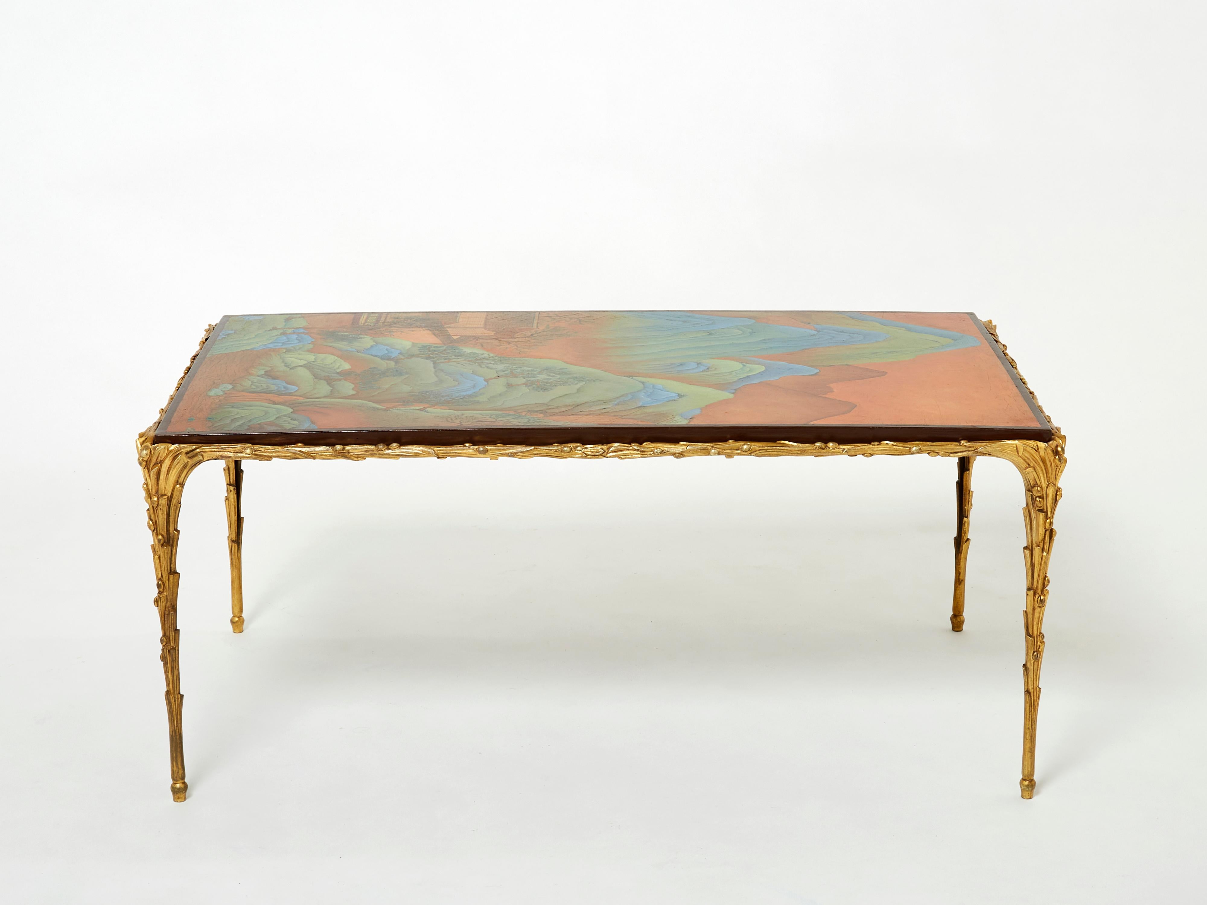 This beautiful coffee table by French house Maison Baguès was created in the early 1960s with solid foliage shaped bronze structure and an amazing Chinese lacquered top picturing a temple in the mountains. The lacquered top is warm and beautiful,