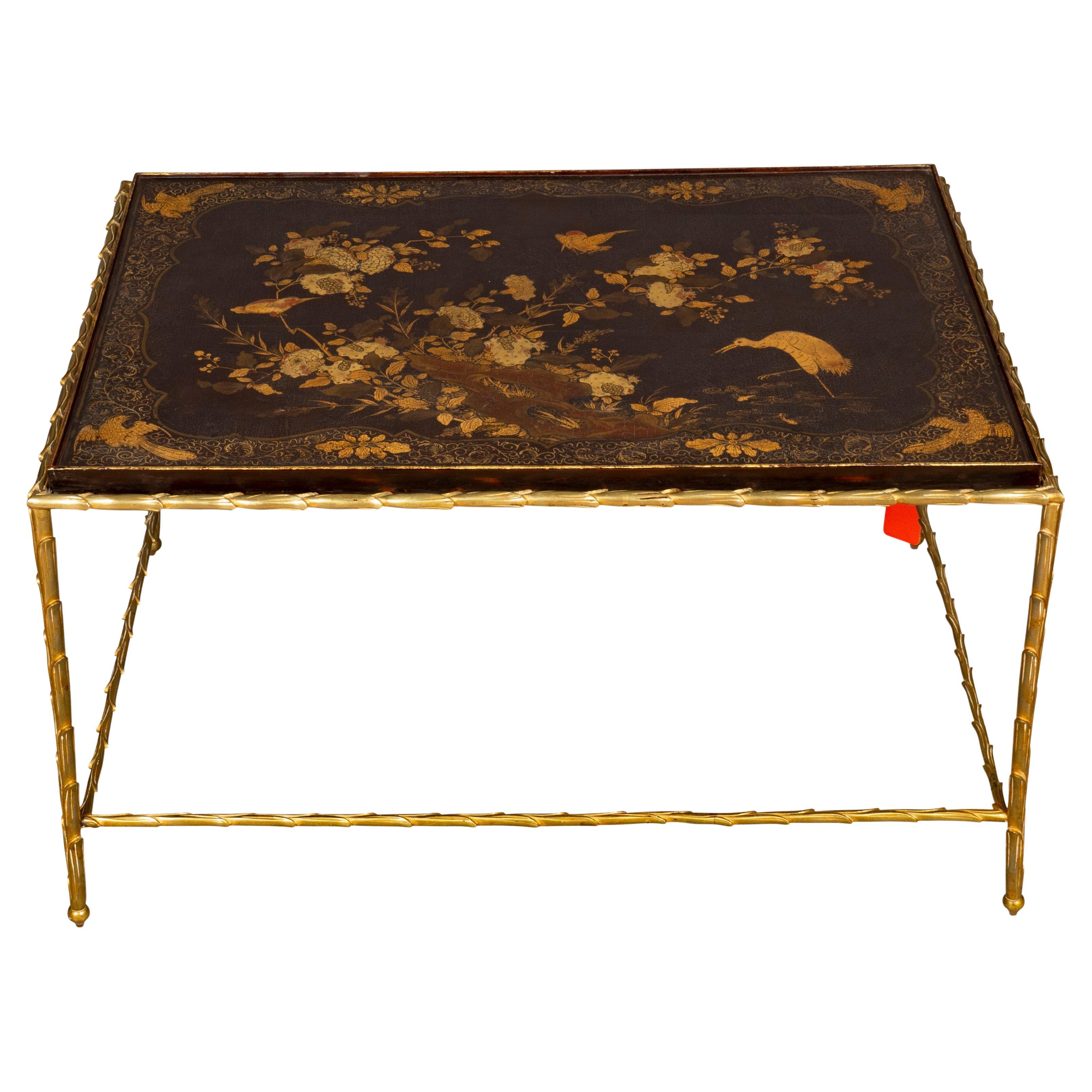 Rectangular with a brown ground and gilded surface with Asian inspired decoration with floral rockwork and bird, brass surround of the top continuing to the legs and stretcher.