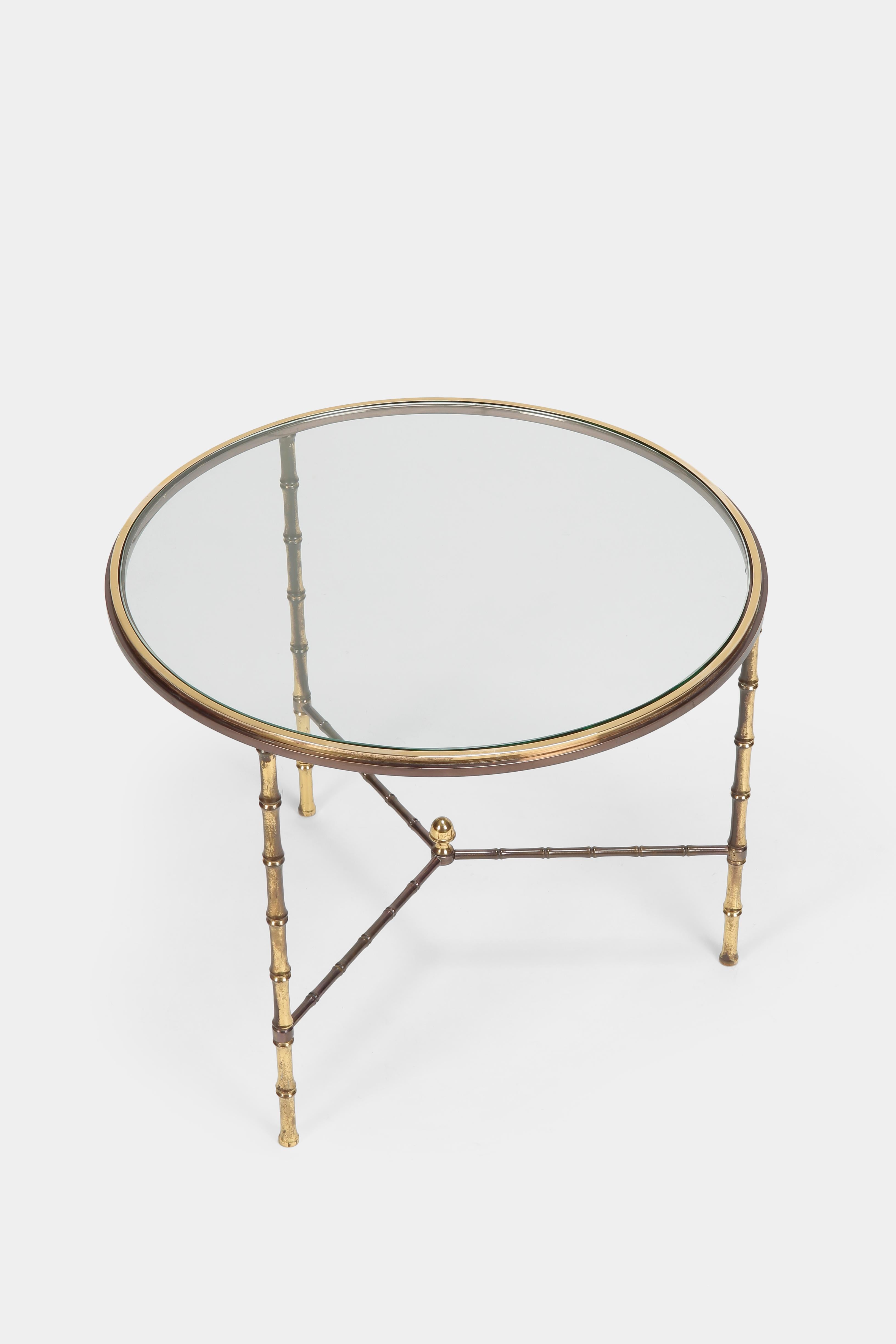 Brass round glass table from Maison Baguès made in Paris, France in the nineteen forties. Harking back to the era of Regency Moderne, also known as Hollywood Regency, this particular style is “Faux Bamboo”, a quintessentially French invention. A