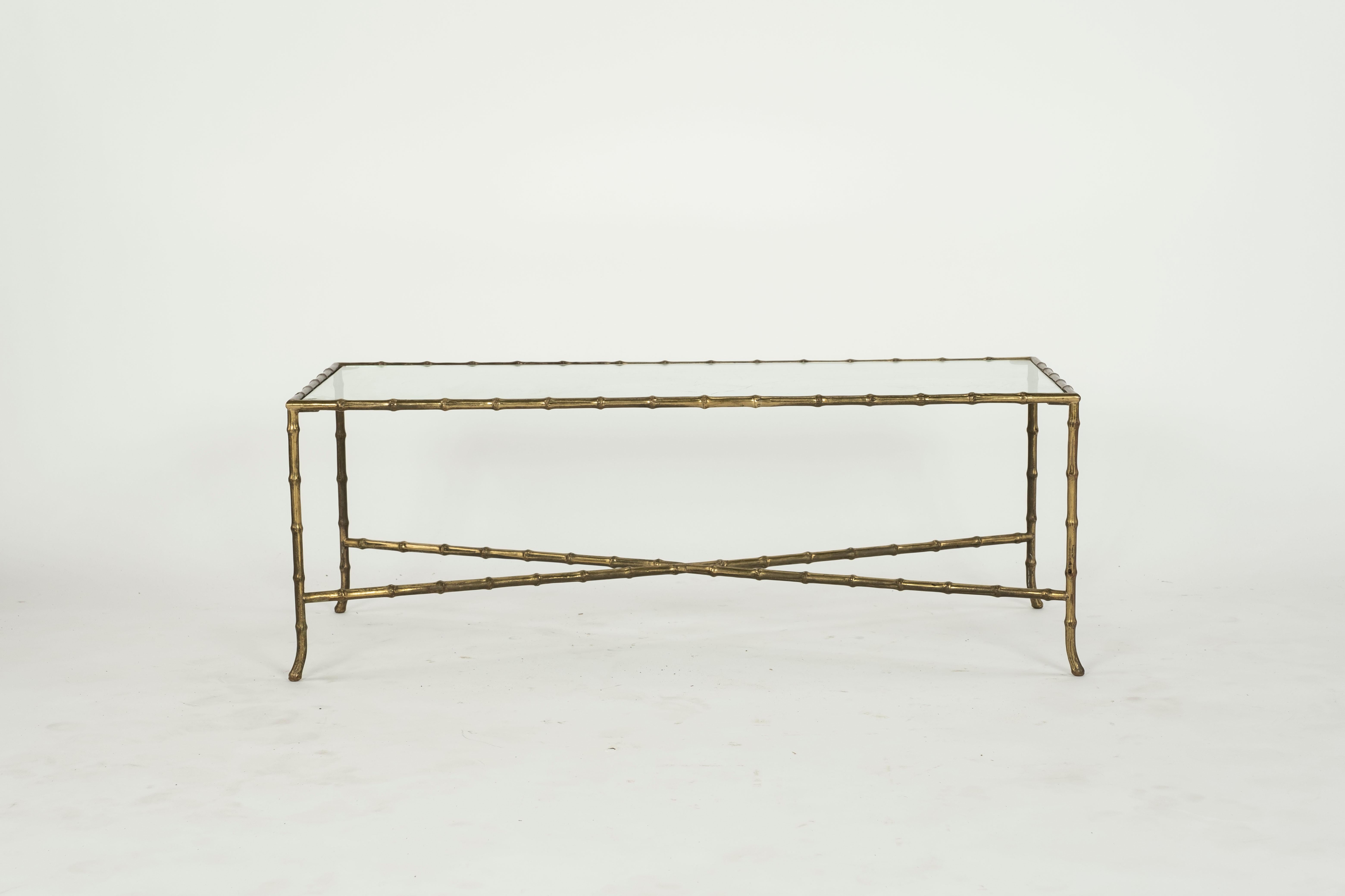 Maison Bagues brass and glass coffee table with faux bamboo design and slightly splayed foot at end. Glass has some scratch marks from previous use but perfectly usable.