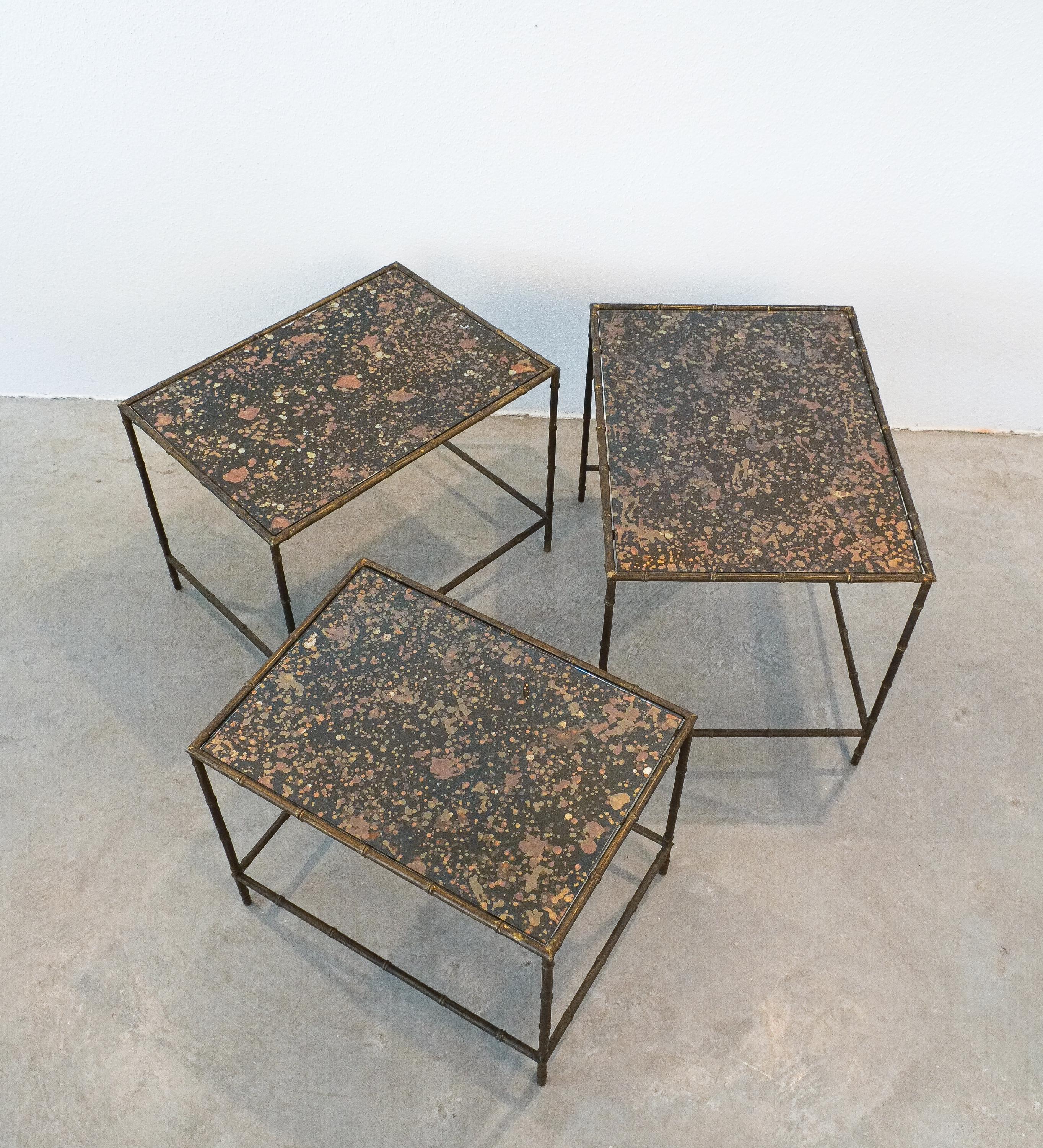 Maison Baguès, Very rare set of 3 nesting tables, France.

The base is made from bamboo brass typical for Maison Bagues, the glass top has got the original silver and gold reflecting mirror still intact. The production of these glass tops was a