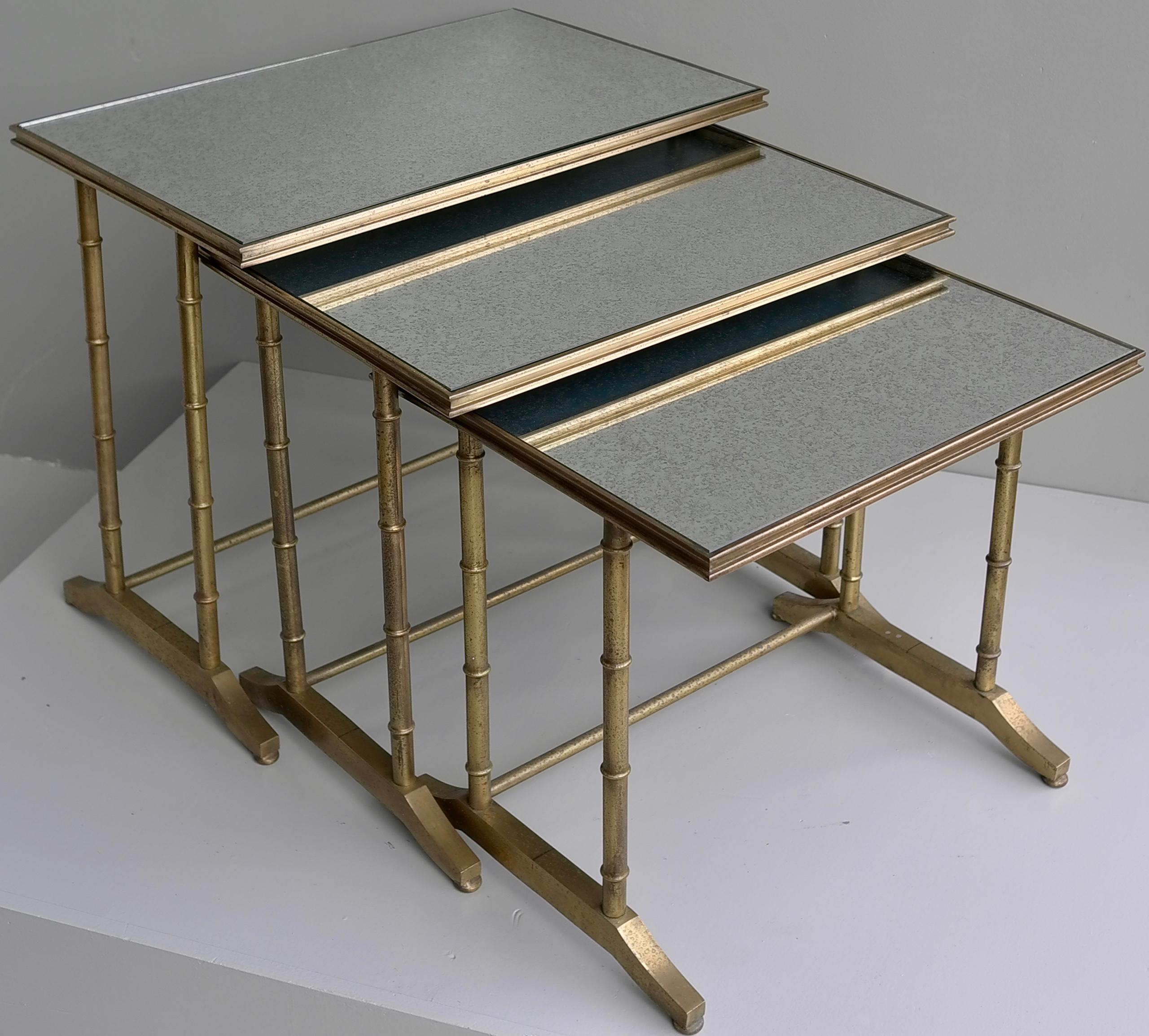 Maison bagues Faux Bamboo Nesting tables, Brass and Mirror Glass, France 1960's.

In Solid brass with aged mirror tops.

Measures: Largest: 66cm x 41cm x 54.5
Middle: 59cm x 40.5cm x 50cm
smallest: 52cm x 41cm x 47cm.