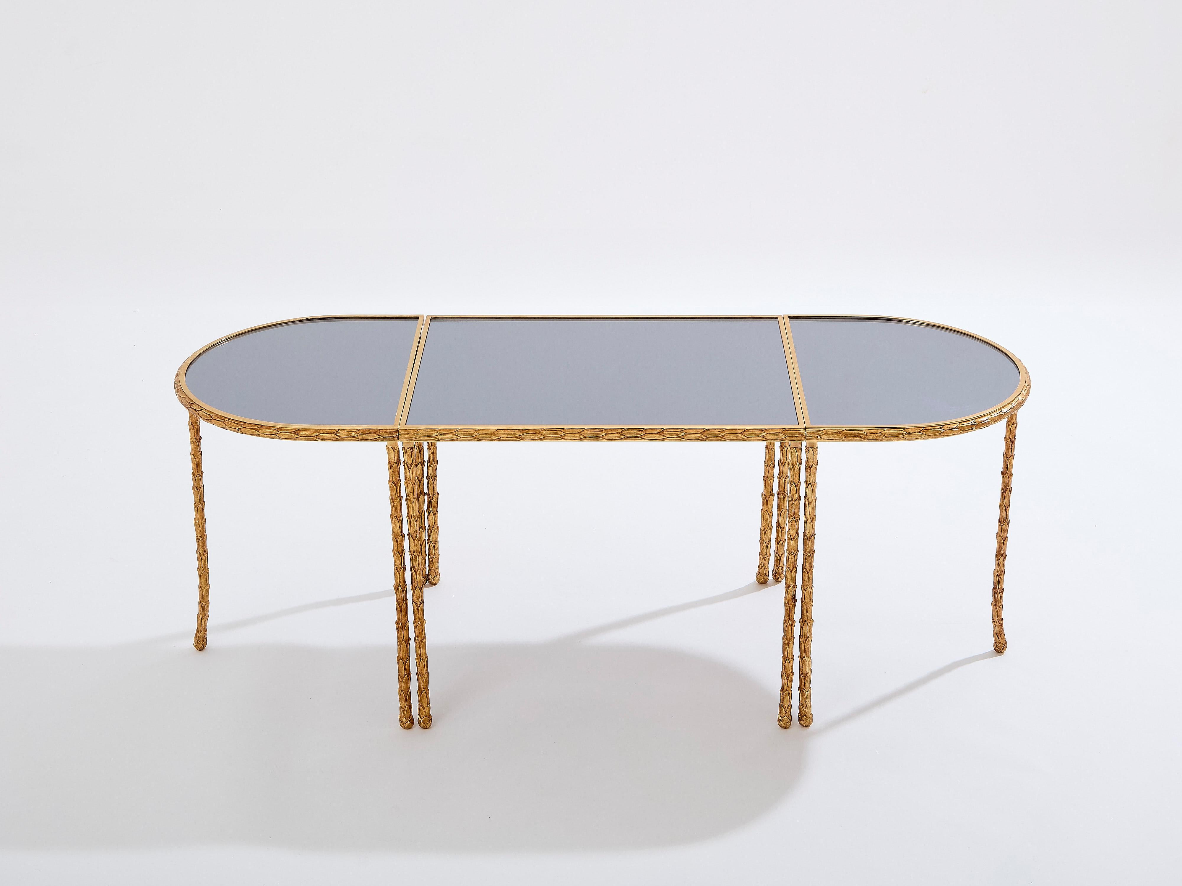 Questo bellissimo tavolino francese della Maison Baguès è stato creato nei primi anni '50 con una solida struttura in bronzo dorato a forma di fogliame e piani in specchio grigio scuro. Il tavolo è composto da tre parti che possono essere separate e