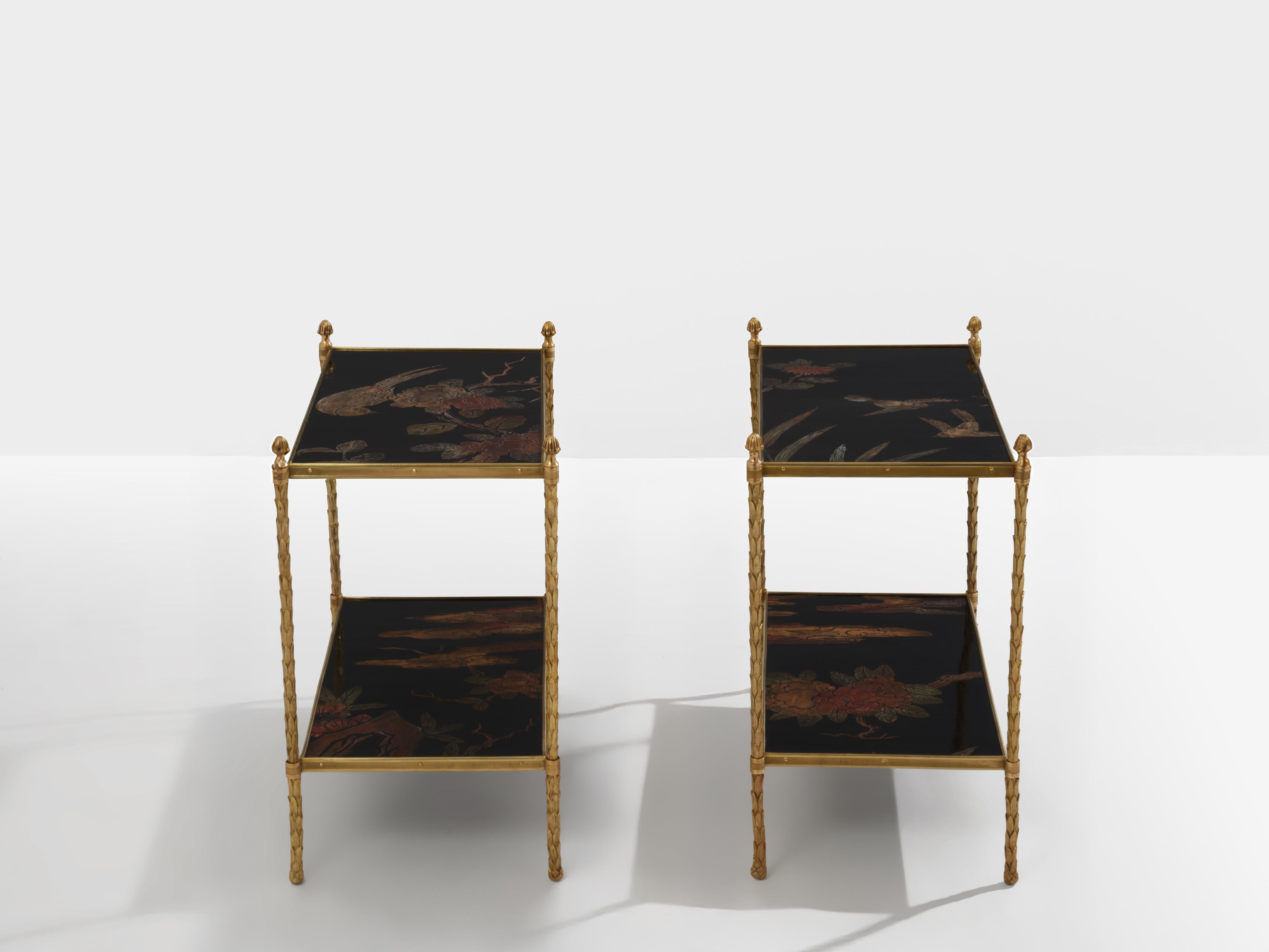 Dieses schöne Paar Chinoiserie-Tische von Maison Baguès mit zwei Etagen wurde in den frühen 1940er Jahren mit einer soliden Struktur aus vergoldeter Bronze in Form von Blättern und einer mit chinesischem Dekor lackierten Platte mit Vögeln und