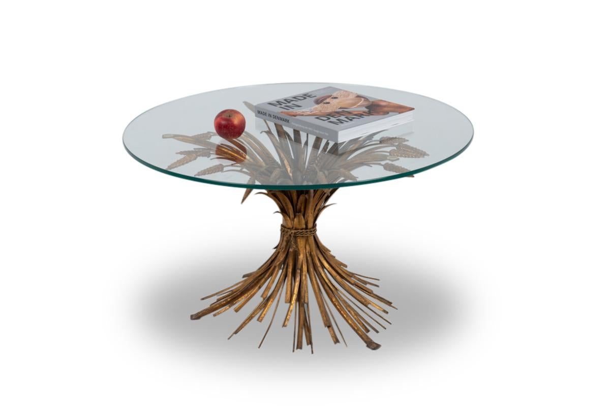 Maison Baguès for Coco Chanel.

Coffee table in gilded metal representing a sheaf of ears of wheat or rye held by a twisted tie supporting a circular clear glass top. The contact of the glass top on the base is made at three points.

French work
