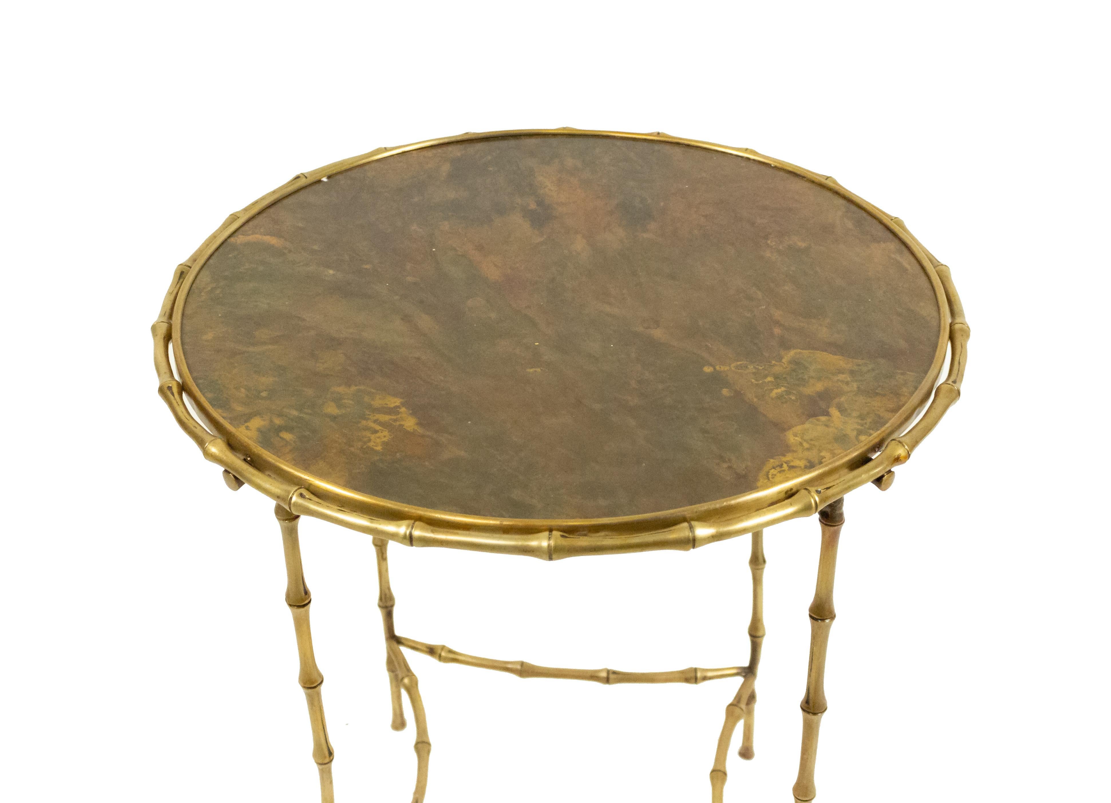 French mid-century round brass end table with faux bamboo top rim and legs connected with a stretcher (MAISON BAGUES).
 