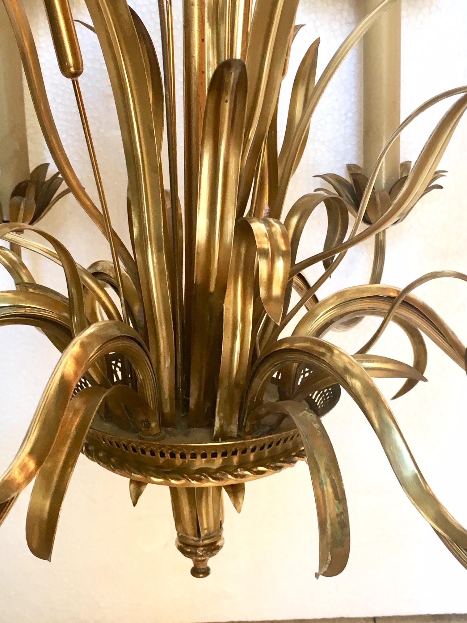 Chandelier lamp attributed to Maison Baguès, in bronze and golden brass, consists of six arms which each end in the form of a flower, the central part of the lamp is decorated with branches and rushes, and plant motifs.
The small lampshades are in
