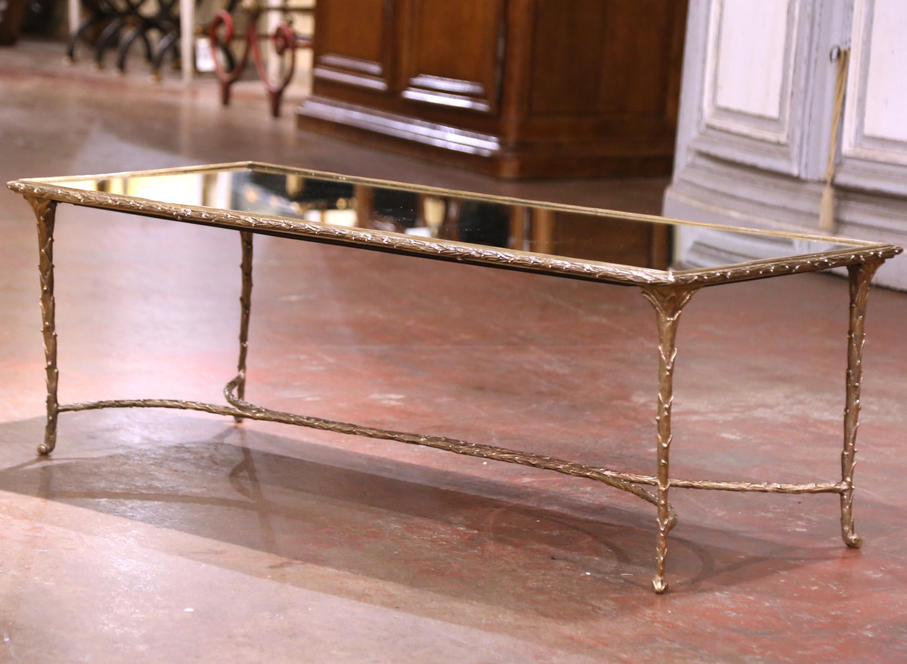 Bring timeless French elegance to your living space with this exquisite vintage coffee table by the esteemed Maison Baguès. Crafted in France circa 1960, the piece features a finely cast gilt bronze frame in the house’s signature faux-bamboo motif,