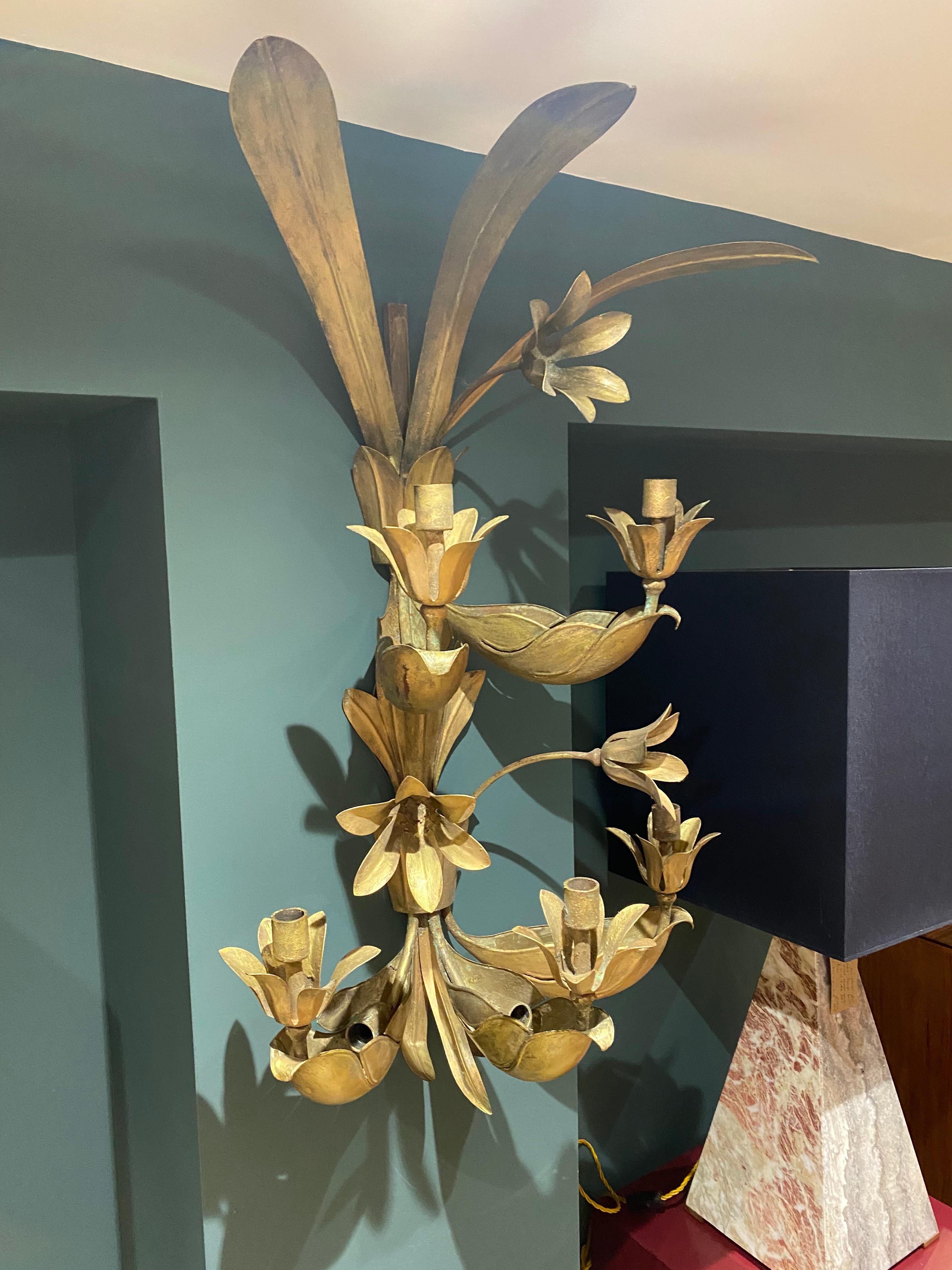 A large pair of Maison Baguès wall sconces with 5 hidden lights and 5 candle holders in the form of palm leaves and flower heads. There is an additional smaller sconce which could be added to the set.
  