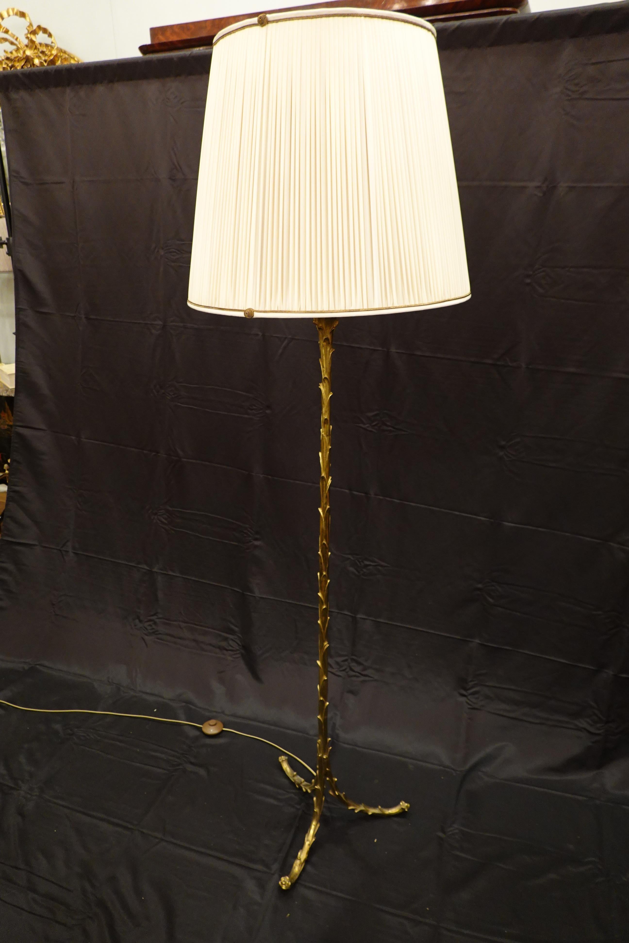 Gilt bronze floor lamp in the form of palm fronds supported on three split legs by Maison Baguès. The lamps includes a new silk, pleated lamp shade custom made in France with 