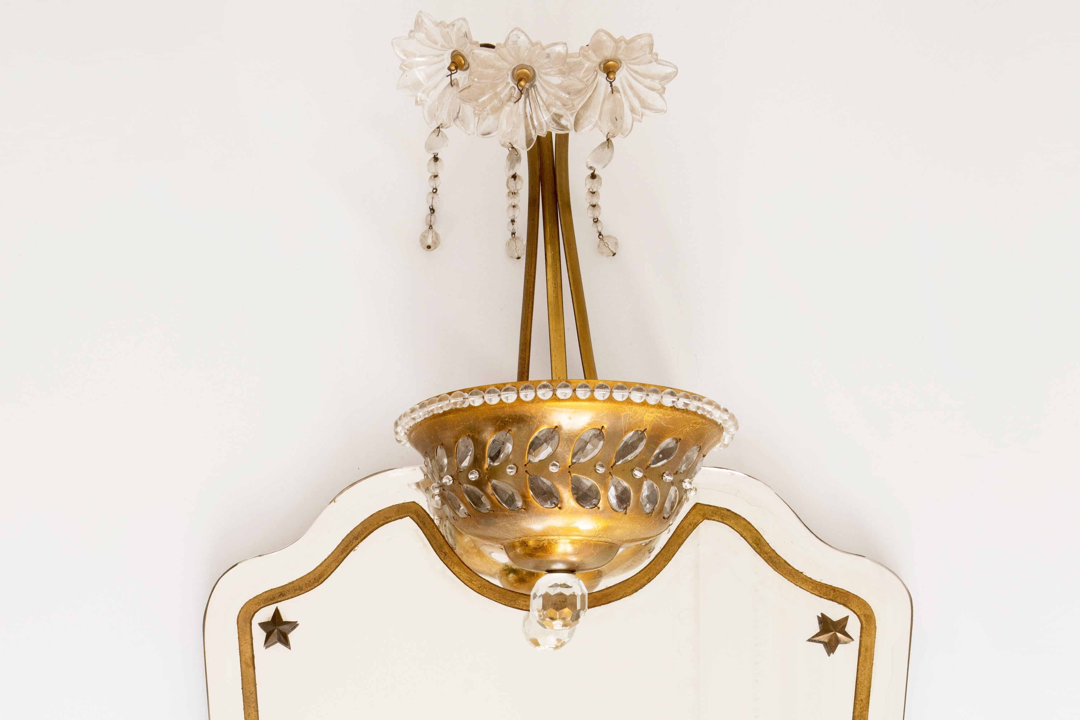 Questo squisito specchio illuminante polilobato della Maison Baguès è uno splendido esempio di artigianato di lusso e di estro artistico, ornato nella parte superiore da un cesto fiorito splendidamente dettagliato realizzato in vetro tagliato, con 3