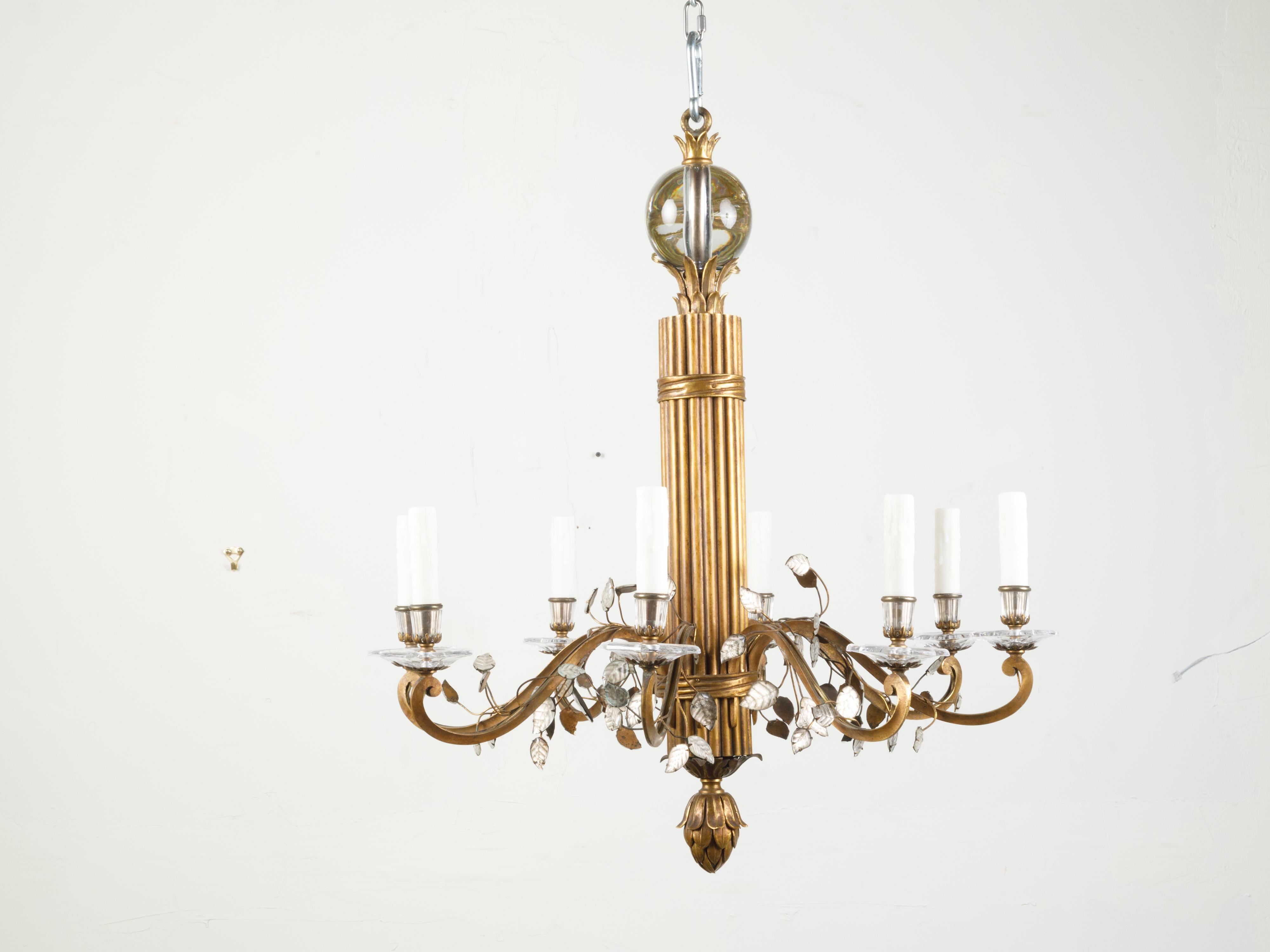 A French Maison Baguès bronze chandelier from the mid 20th century, with eight lights and rock crystal motifs. Created by Maison Baguès during the midcentury period, this chandelier features a central torch style reeded column connected to eight