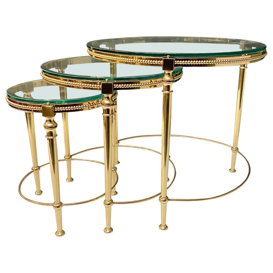 This is a superb set of three brass and glass nesting tables that are attributed to Maison Baguès. The tables date to the mid-20th century and are beautifully detailed in fine beading to the rims of the tables and engine turnings to the top of legs.