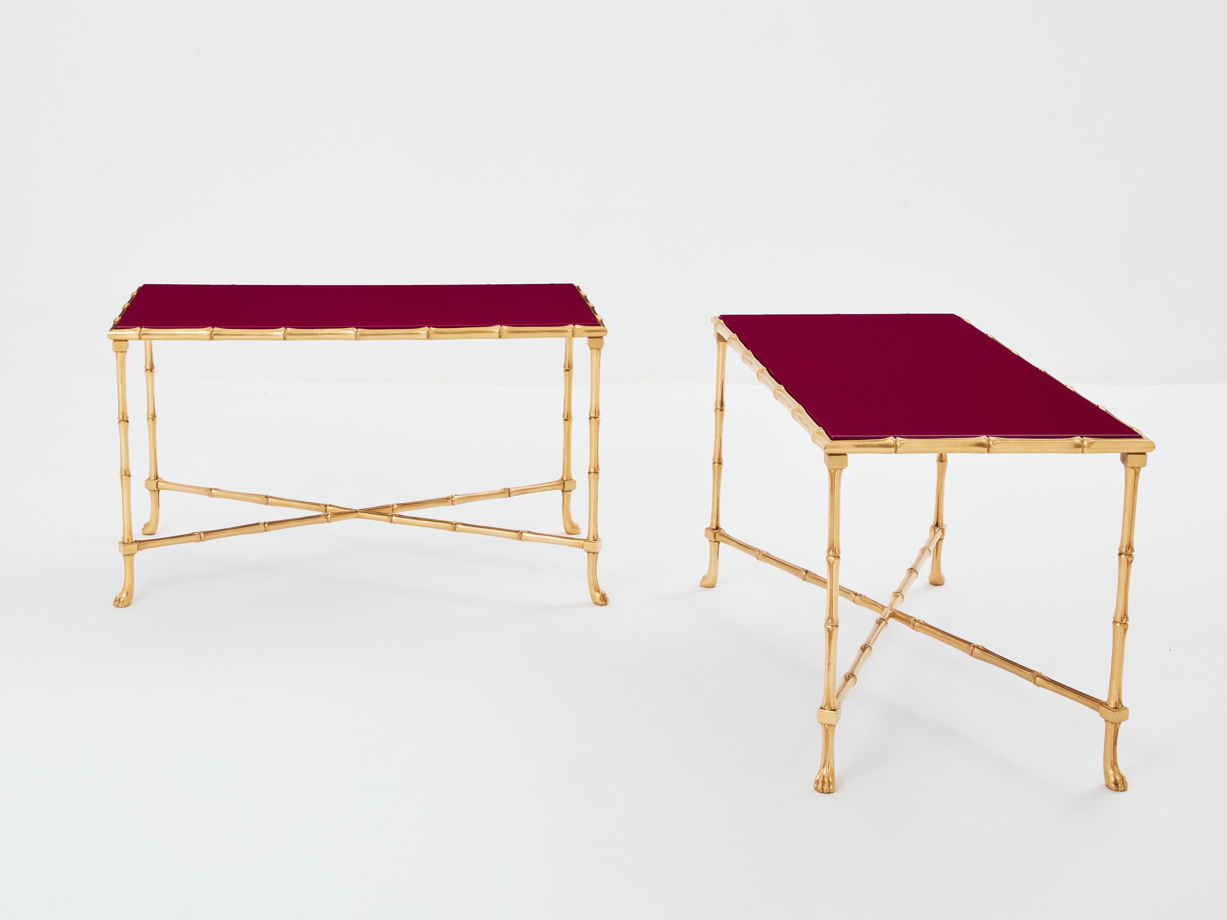 Cette magnifique paire de tables d'appoint de la Maison Baguès a été créée avec du laiton massif en forme de bambou et de magnifiques plateaux en laque rouge framboise au début des années 1960. Les plateaux laqués sont intemporels et lisses, tandis