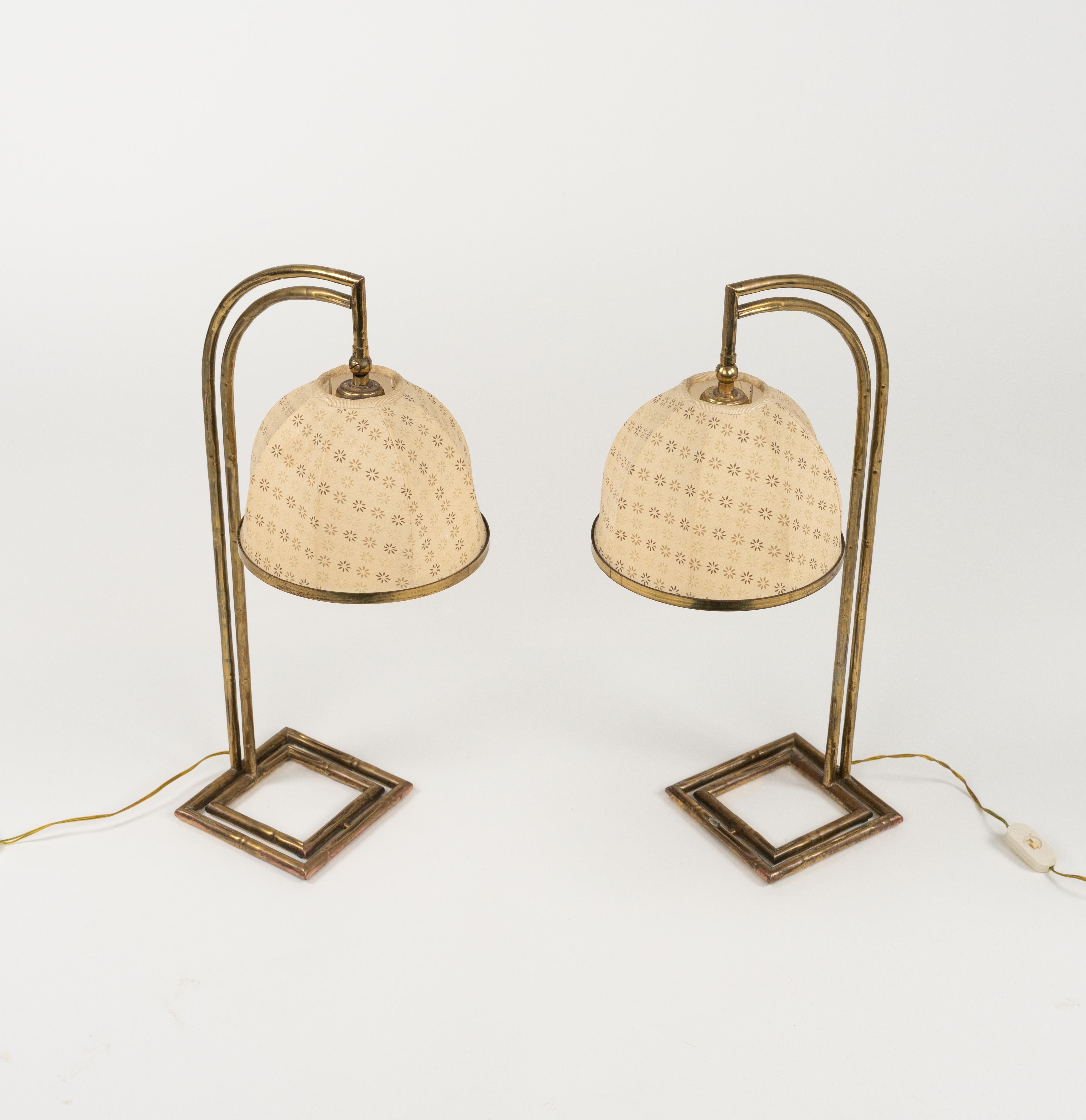 Midcentury amazing pair of adjustable table lamp in brass faux bamboo and fabric lampshade in the style of Maison Baguès.

Made in Italy in the 1960s.

A beautiful pair of lamps that is perfectly working. European plug (works outside EU with a