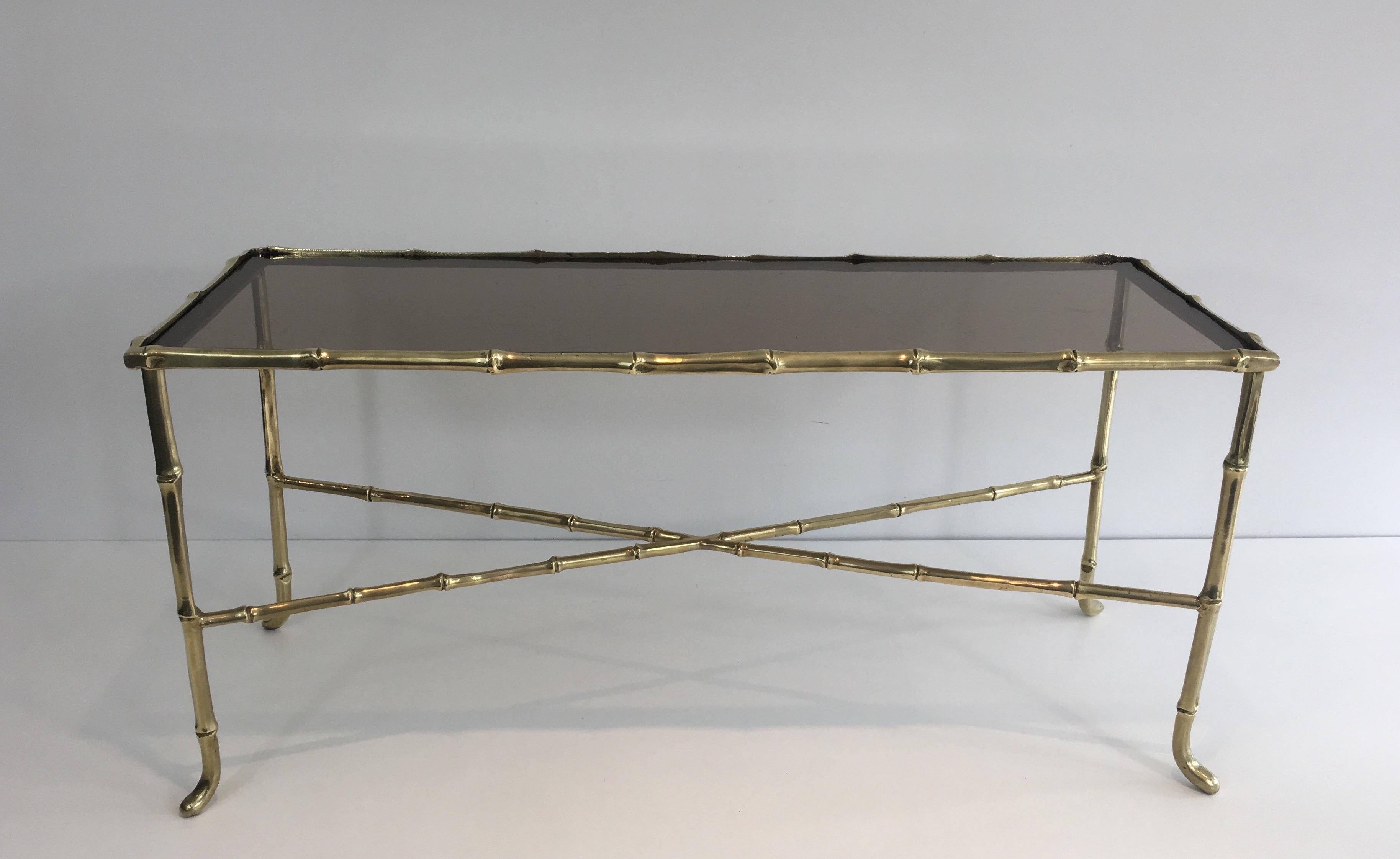 This very nice small coffee table is made of a beautiful faux-bamboo bronze with a smoked glass on top. This is a very Fine work by famous French maker Maison Baguès, circa 1940.