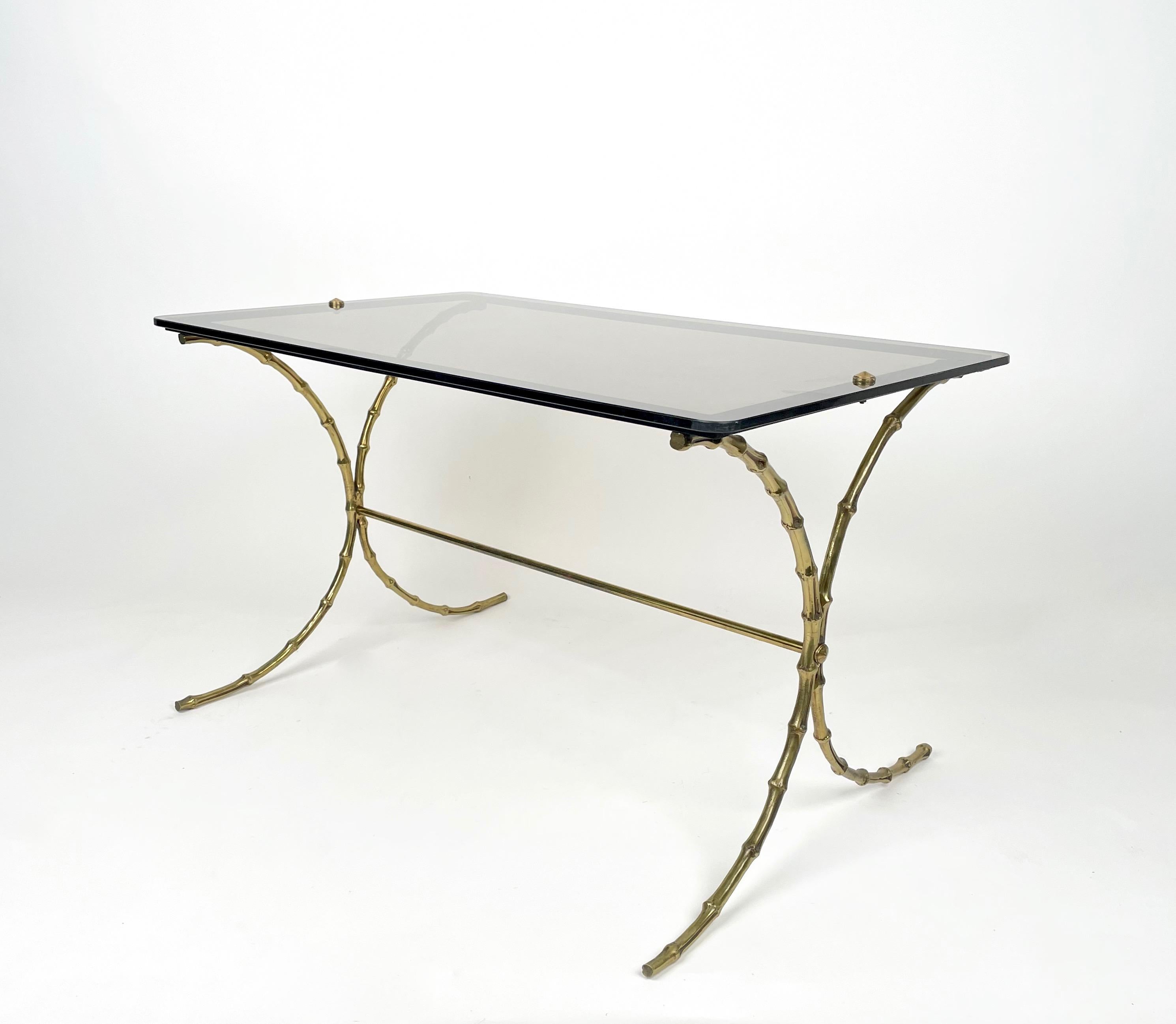 Coffee table featuring a rectangular smoked glass surface supported by a faux bamboo brass structure with curved legs by Maison Baguès.

 Made in France in the 1970s.