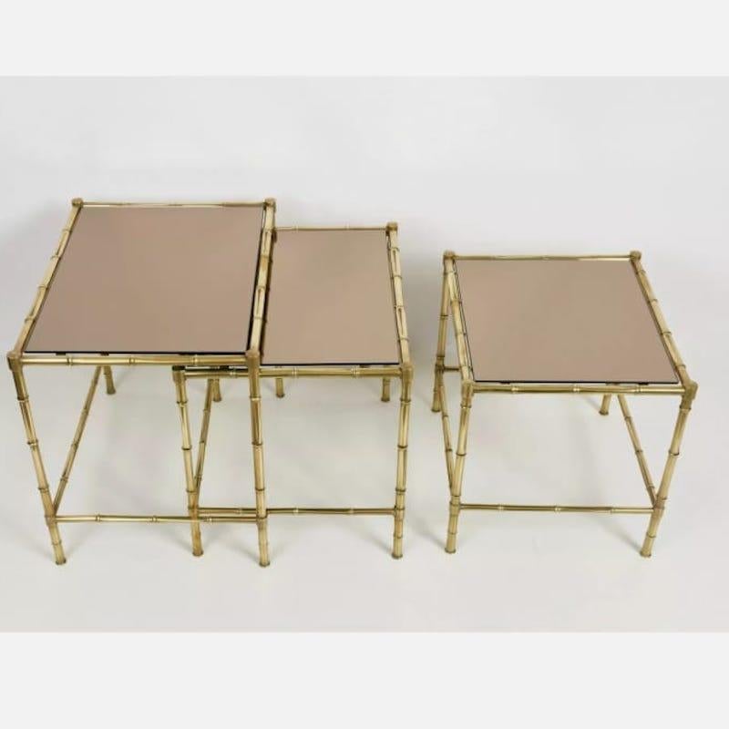 Maison Baguès style brass faux bamboo legs small tables set.
A set composed of three small tables with brass legs and bronze mirrored tops.
The size of the tables are ( the bigger) are W 52 cm x D 39 cm, H 46 cm
Excellent conditions. Brass with