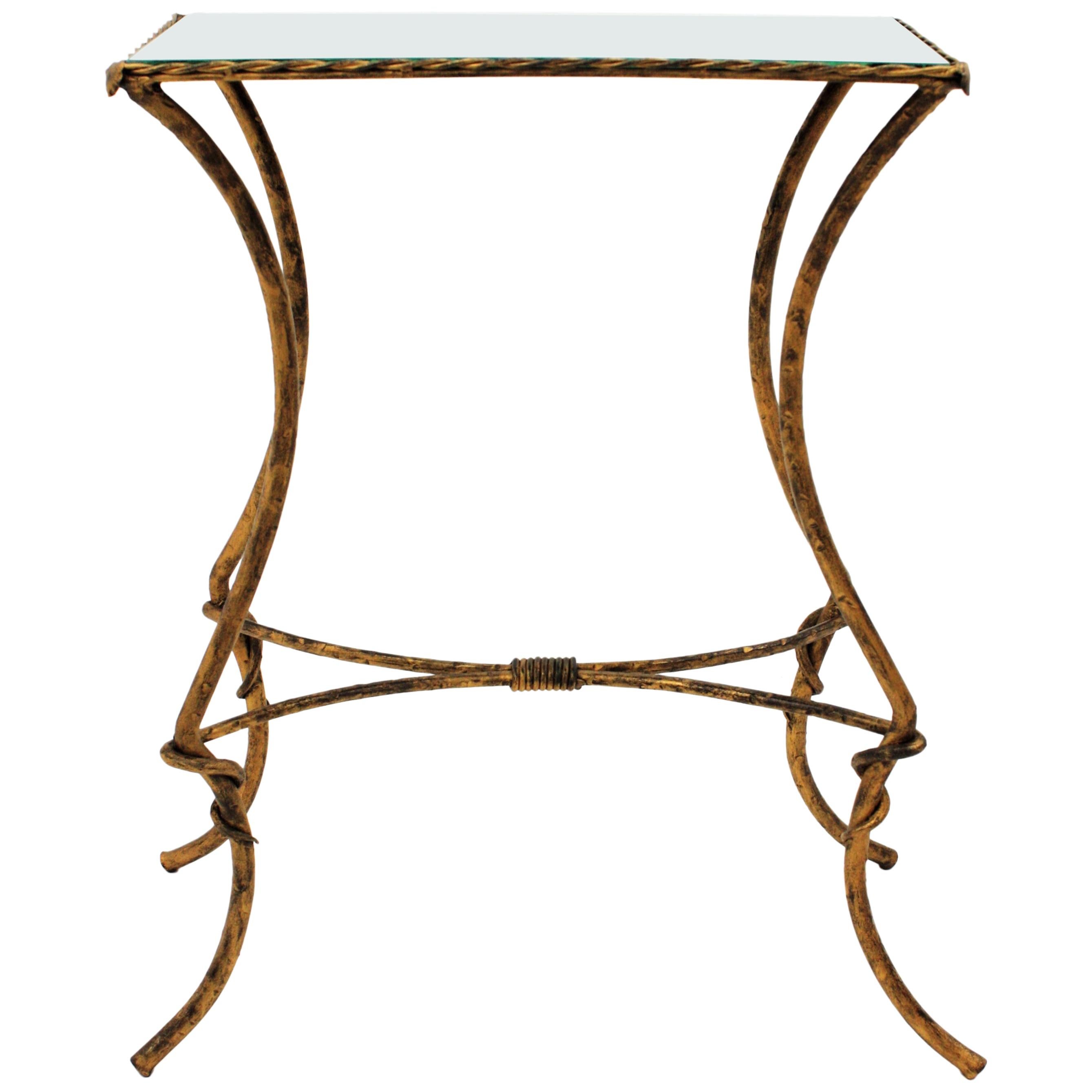 Chic French wrought iron drink table with rectangular mirror top and parcel-gilt finish.
Beautifully designed at the Hollywood Regency period inspired by Maison Baguès pieces.
It has a mirror glass rectangular top surrounded by a twisted iron