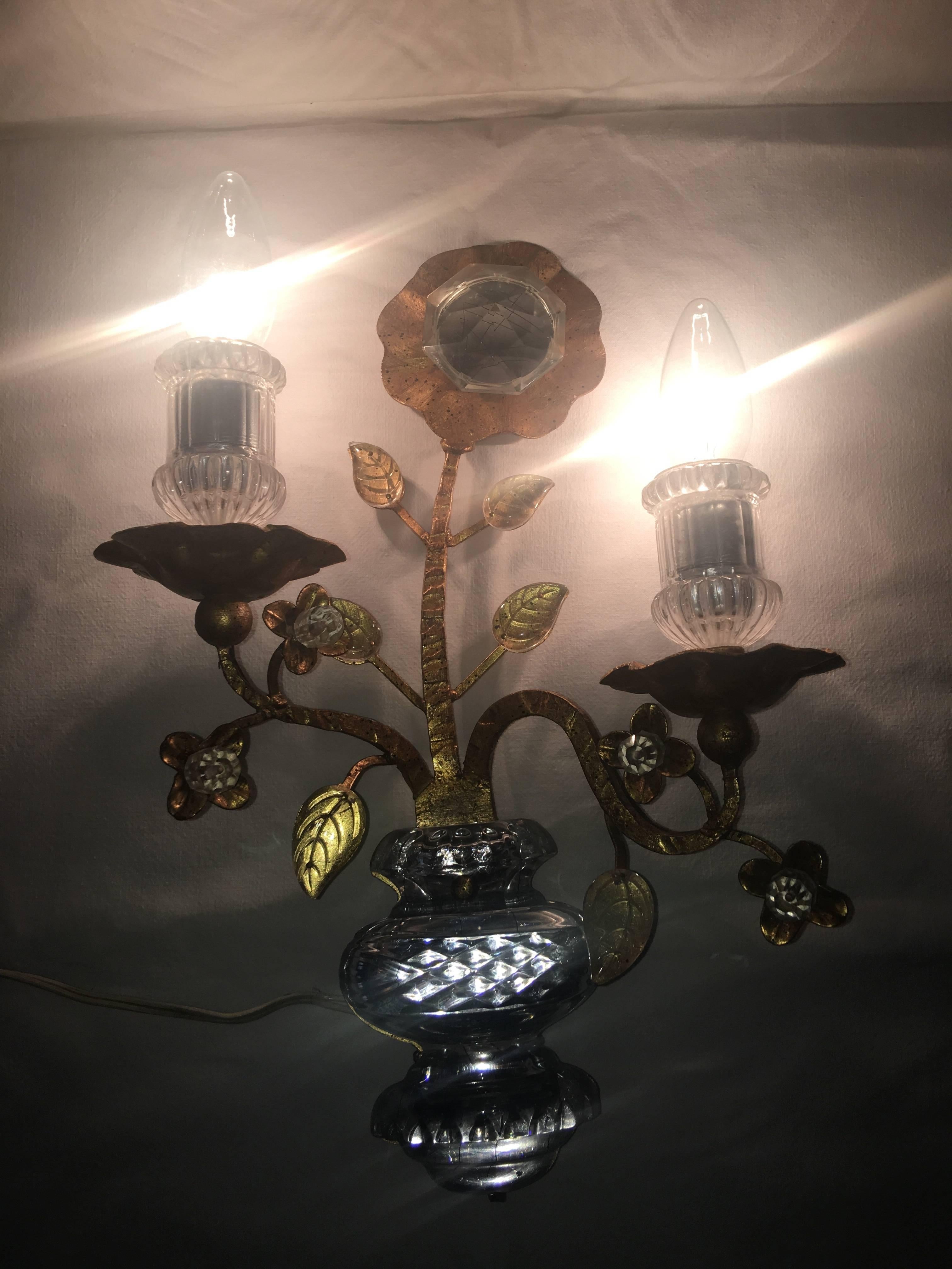 A single Sconce with a beautiful dual light effect. In the famous Maison Baguès style it features a gild gold finish on Iron with delicate crystal glass.
It requires two E14 European candelabra bulbs, each up to 40 watts. This gorgeous fixture will