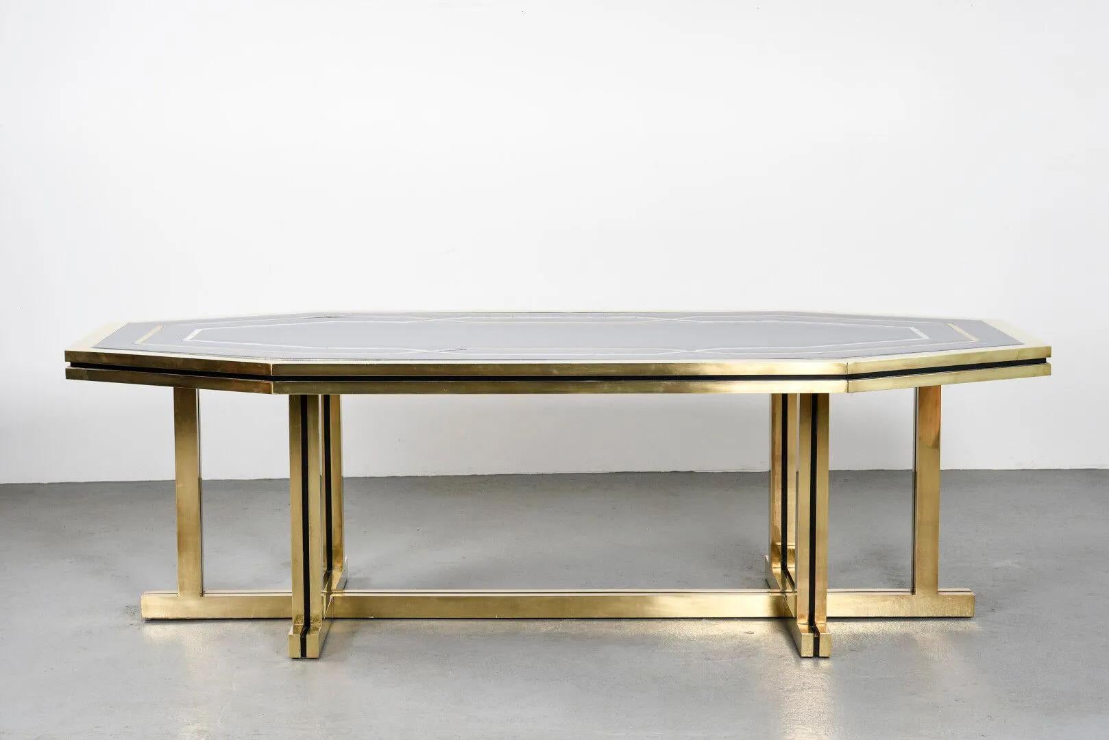 Tavolo da pranzo molto grande con base in ottone dorato da cui poggia uno spesso piano a forma ottagonale in 
laccato blu con intarsi in madreperla. Ha due spesse barre in ottone dorato intorno al bordo.
Ordine speciale per l'Ambasciata del Paese